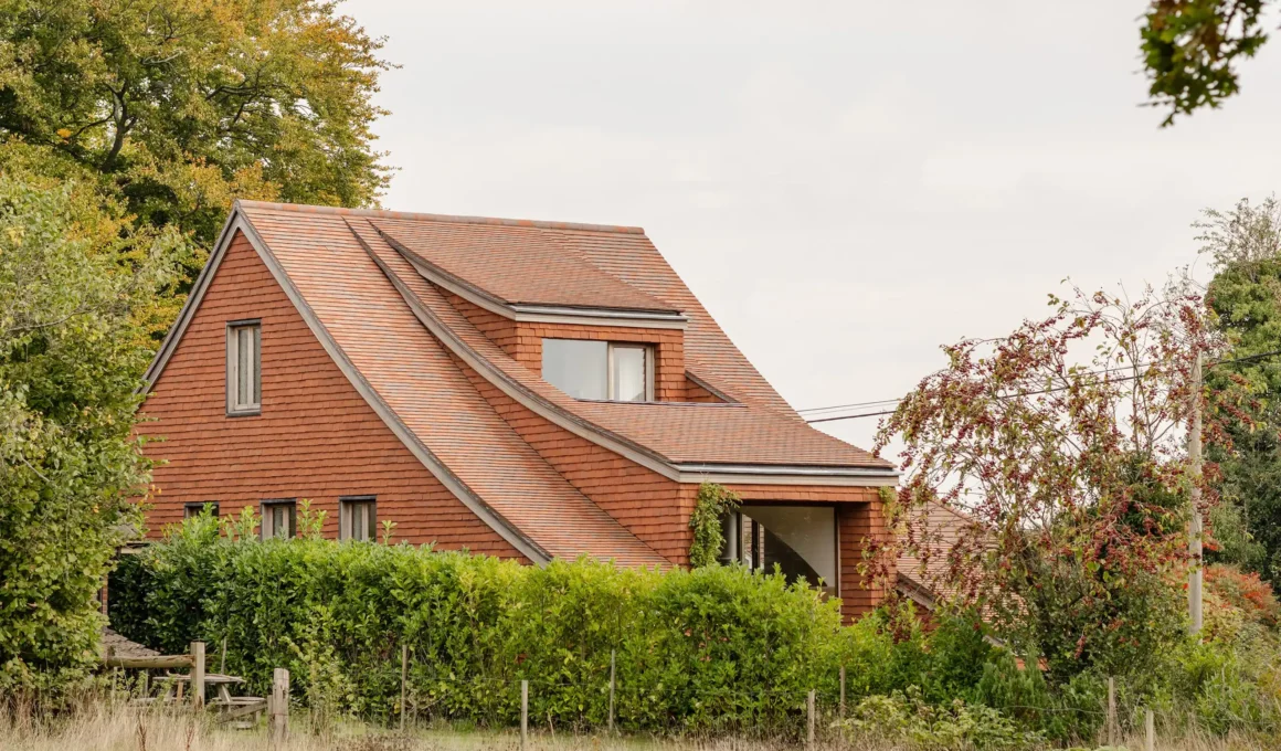 Side profile of Clay Rise showing tiered red clay tile roof and walls in West Sussex