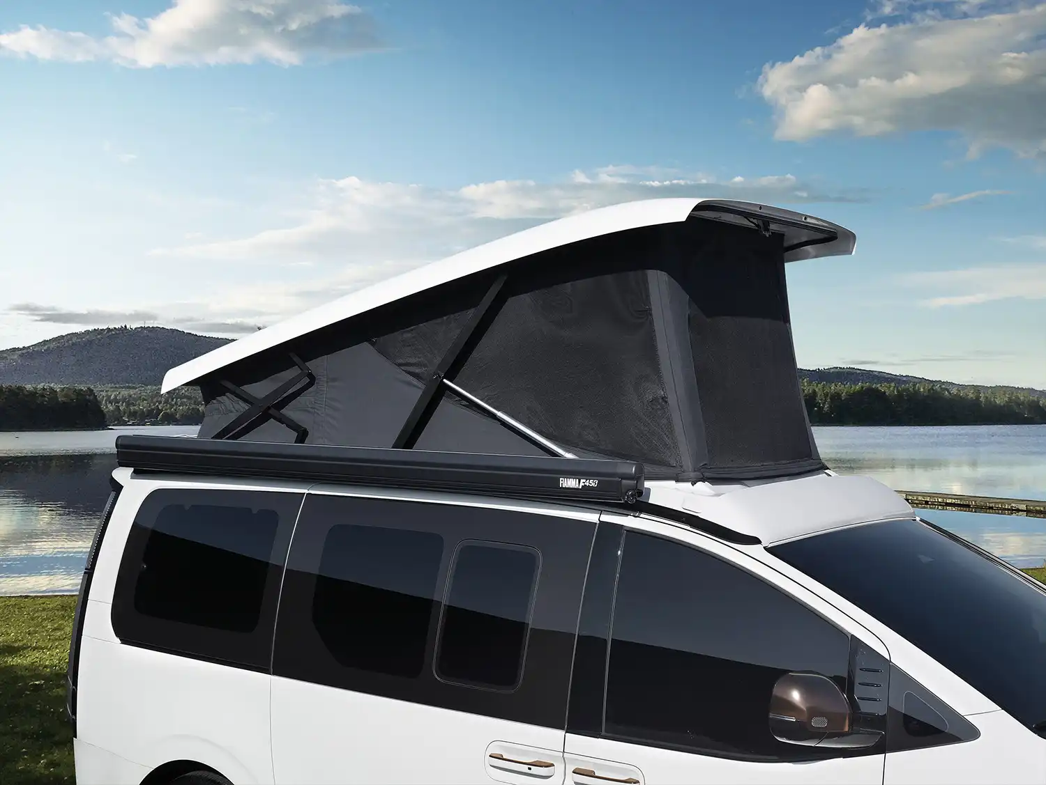 Close-up of the STARIA Camper’s power-operated pop-up roof and Fiamma awning.