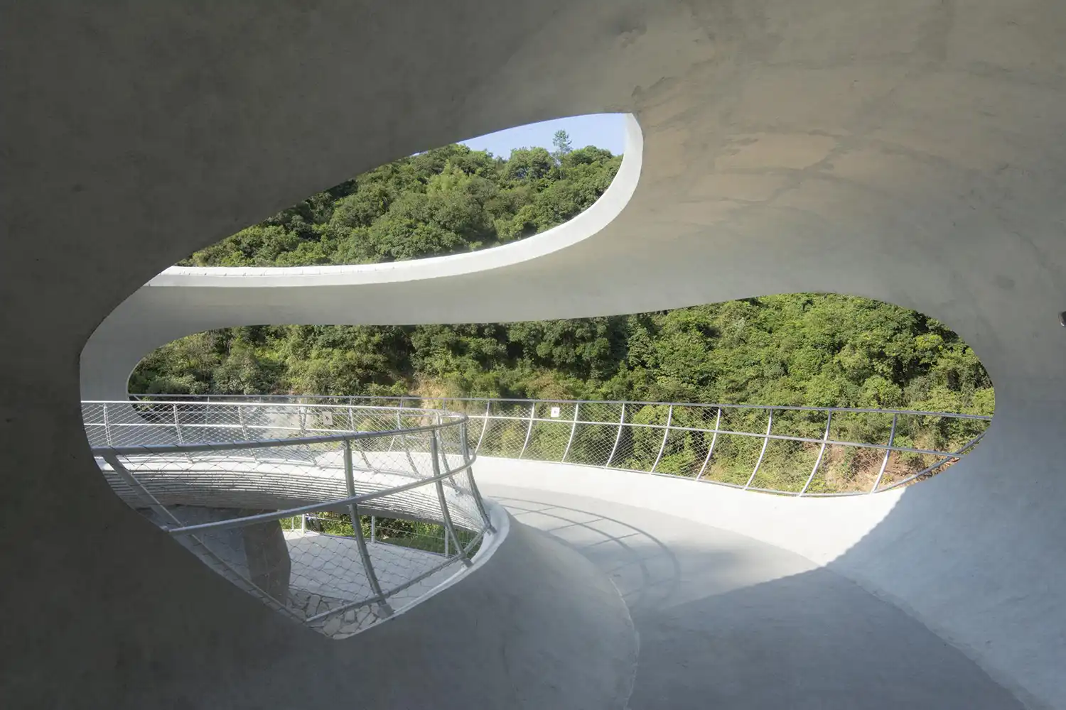 Interior view of concrete pavilion framing mountain vistas