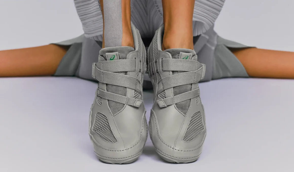 A frontal view of the grey HYPER TAPING™ sneakers featuring a minimalist monochromatic design with three elastic support bands.