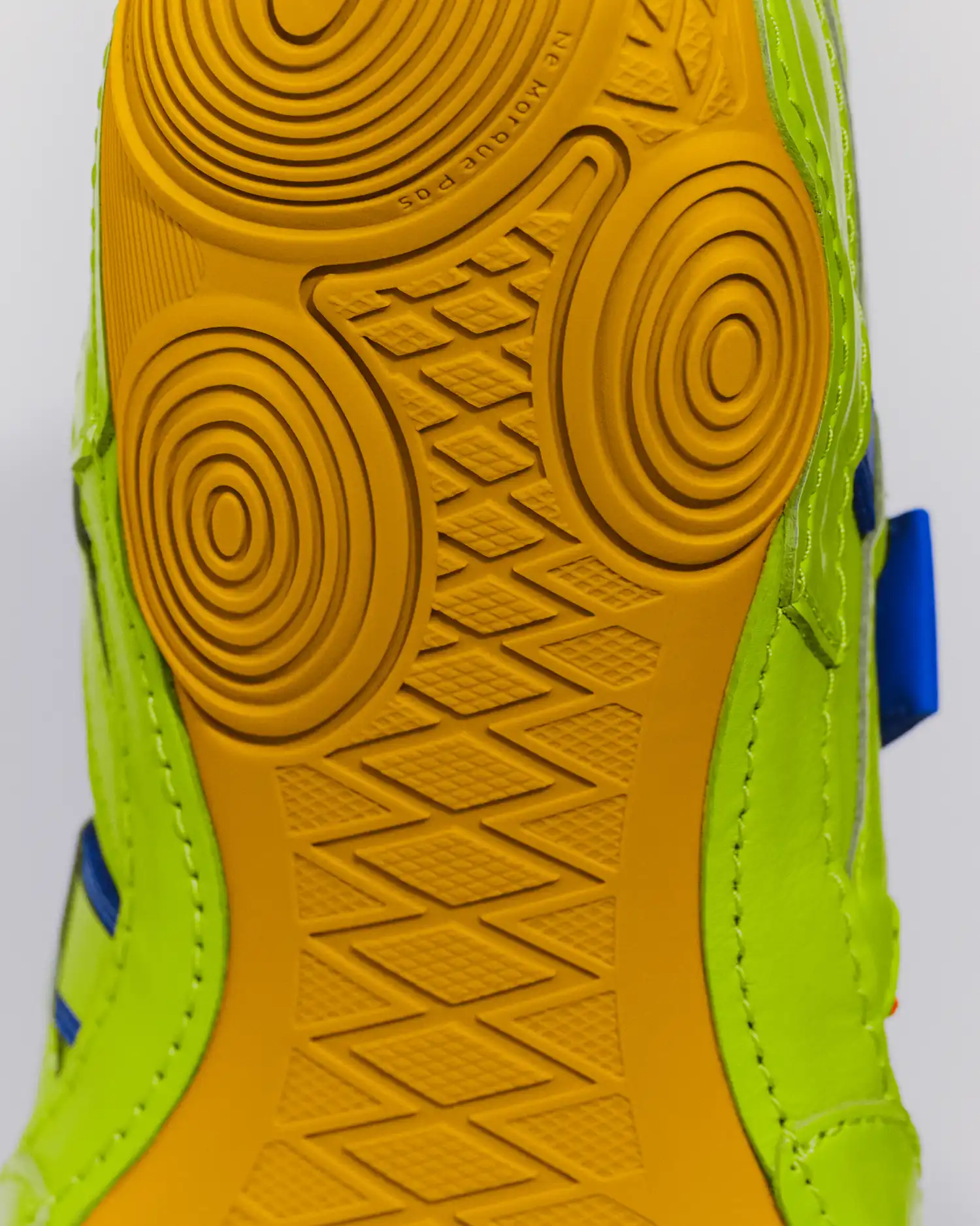 A macro view of the yellow wrestling-inspired outsole featuring a "gecko-foot" concentric circle tread pattern for enhanced grip.