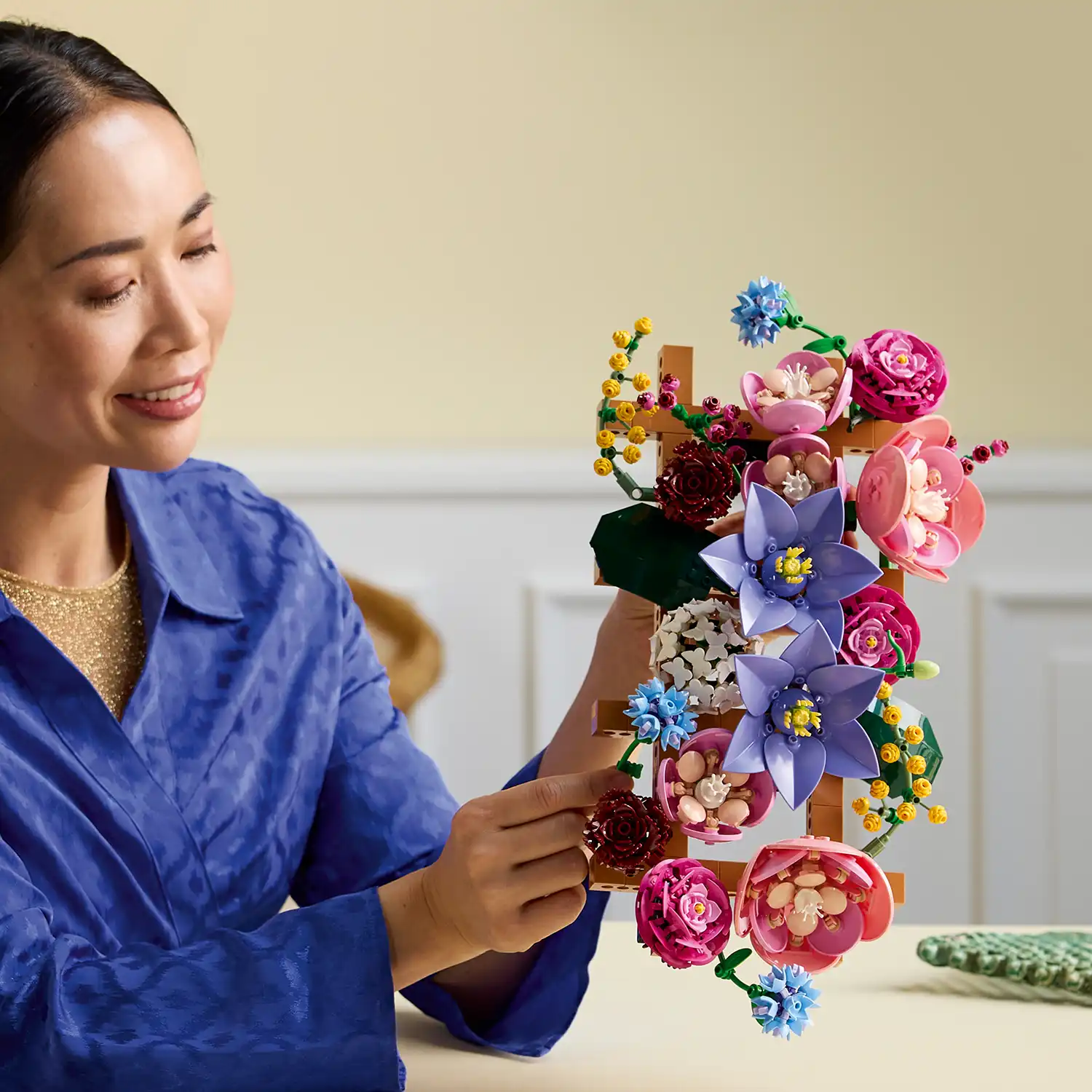 Close-up of a person holding a vertical LEGO Flower Wall trellis.
