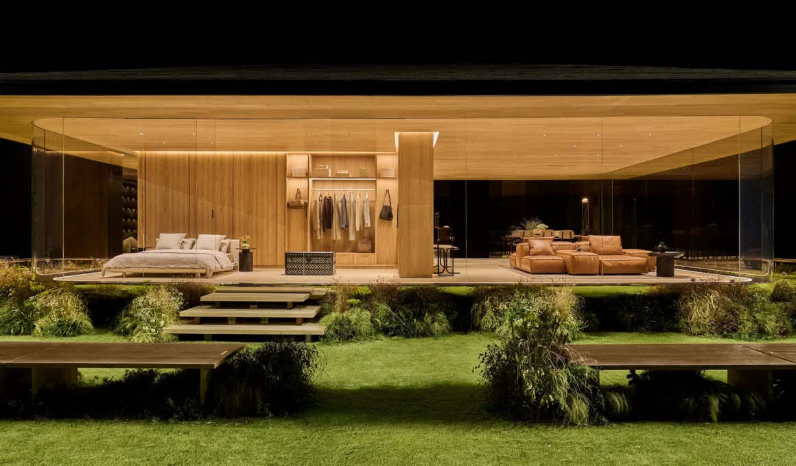 Exterior night view of DROPHAUS prefab home with warm interior lighting and glass walls.