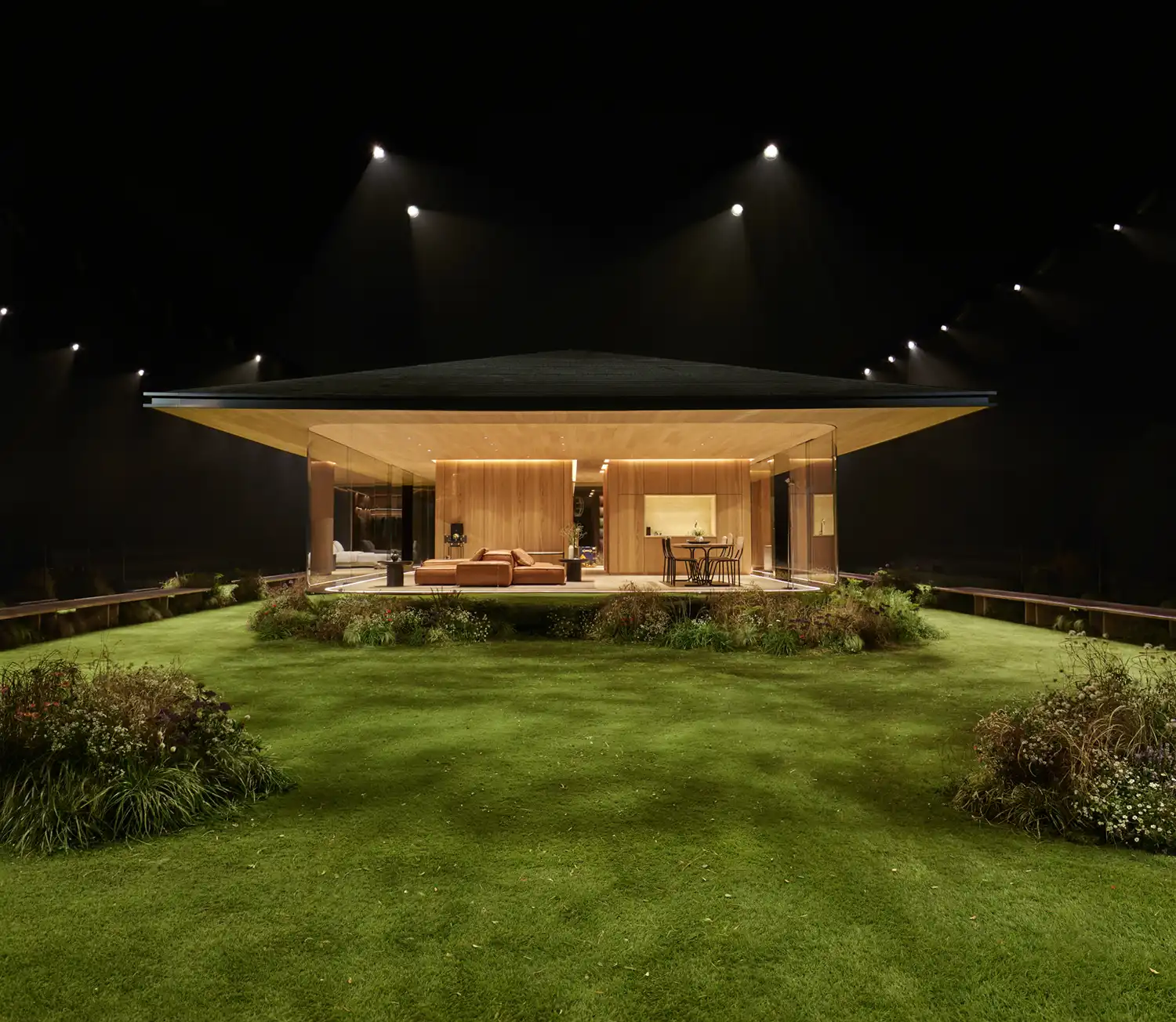 Wide shot of the DROPHAUS structure in a Parisian garden under spotlights at night.