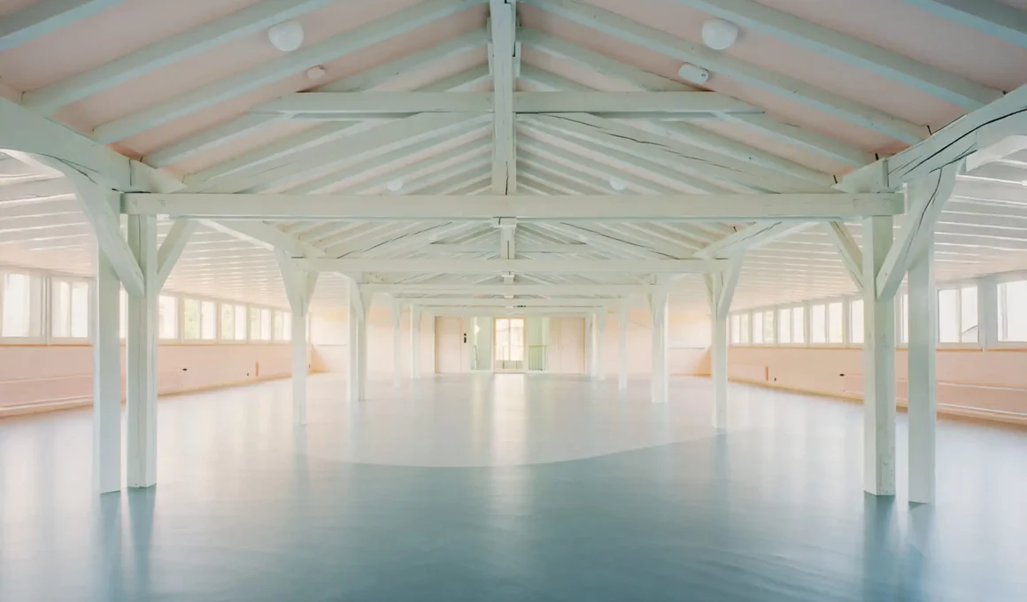 Expansive attic play area in Basel with white timber trusses and light blue flooring.