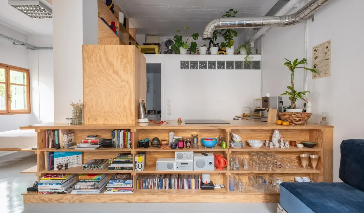 Low-profile pine plywood kitchen island with integrated shelving and industrial ductwork above.