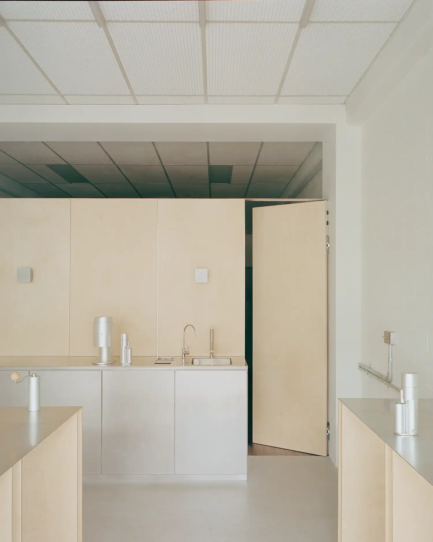 Minimalist timber feature wall with a hidden pivot door in the PerCapita designed gallery.