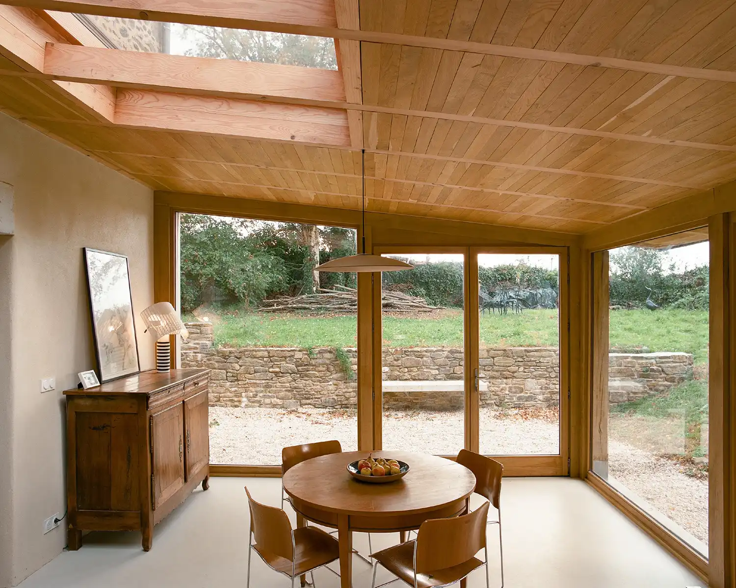 Contemporary dining room extension with a wooden ceiling and large floor-to-ceiling windows.