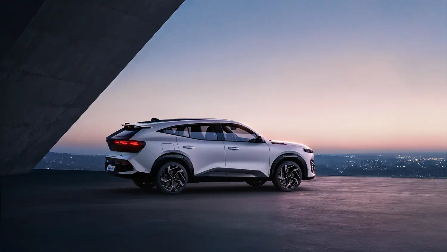 Side profile of the Renault Filante premium crossover showing its "genre-crossing" fastback silhouette, 20-inch alloy wheels, and flowing roofline against a minimalist architectural background.