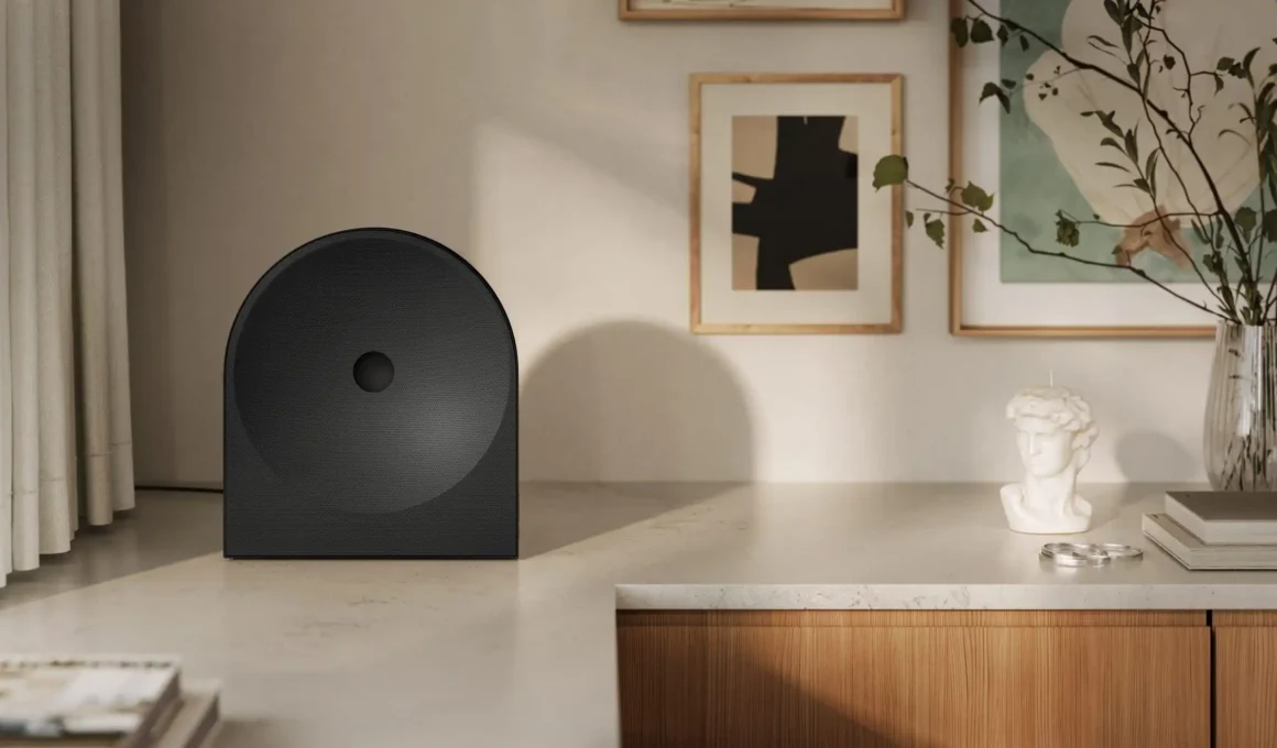 A Samsung Music Studio 7 Wi-Fi speaker, designed by Erwan Bouroullec, displayed as a sculptural object on a minimalist stone countertop within a refined domestic interior.