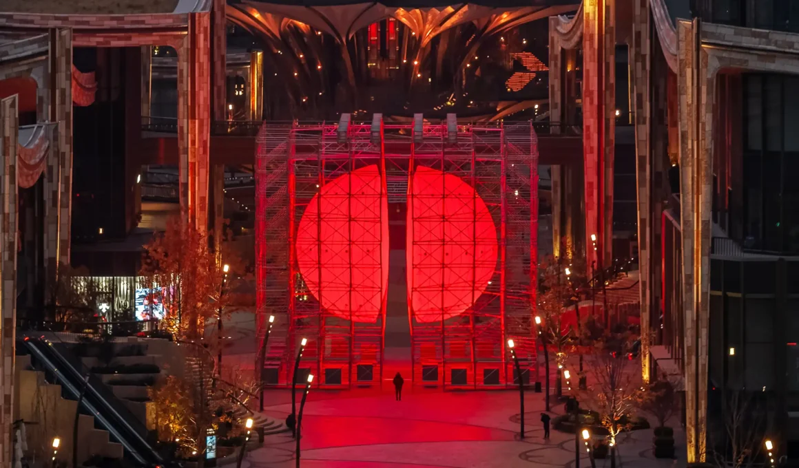 A symmetrical view of the DIVIDED installation positioned in a plaza flanked by the organic, tiered ceramic buildings designed by Heatherwick Studio in Xi'an.
