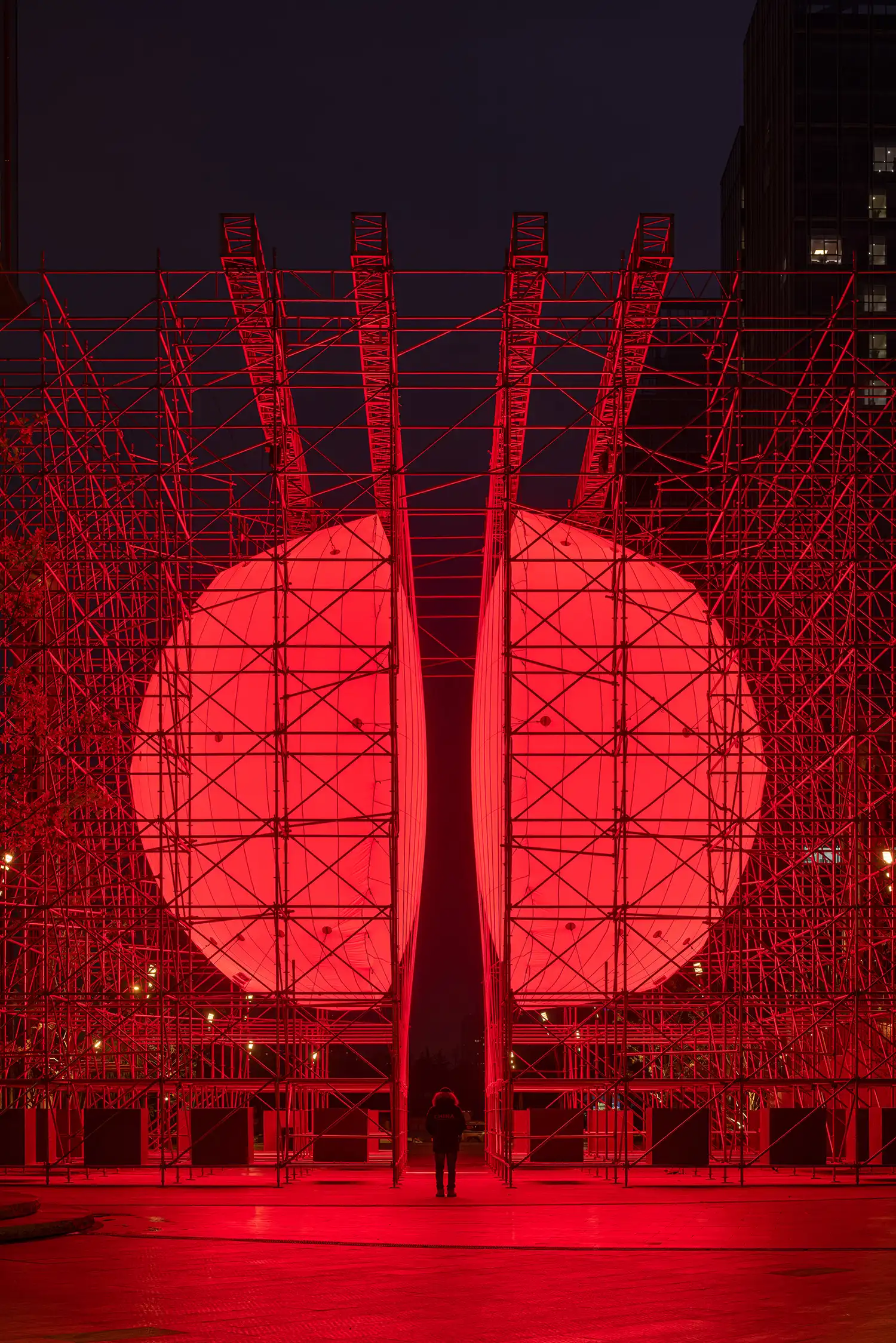 A perfectly centered front view of SpY's DIVIDED sphere, showing the two identical halves separated by a dark central corridor under a night sky.