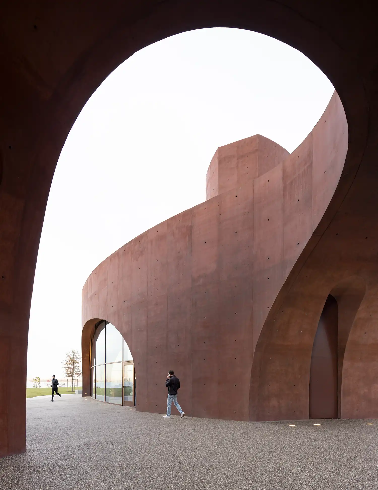 A detail shot of the pavilion's curving facade and large glass windows.