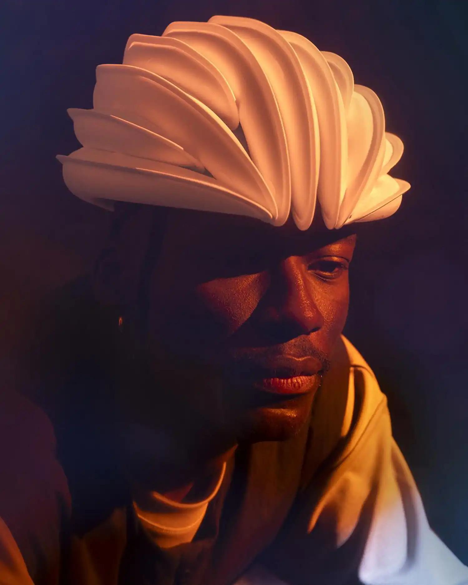 Close-up portrait of a person wearing the white Ventete aH-1 helmet under warm lighting.