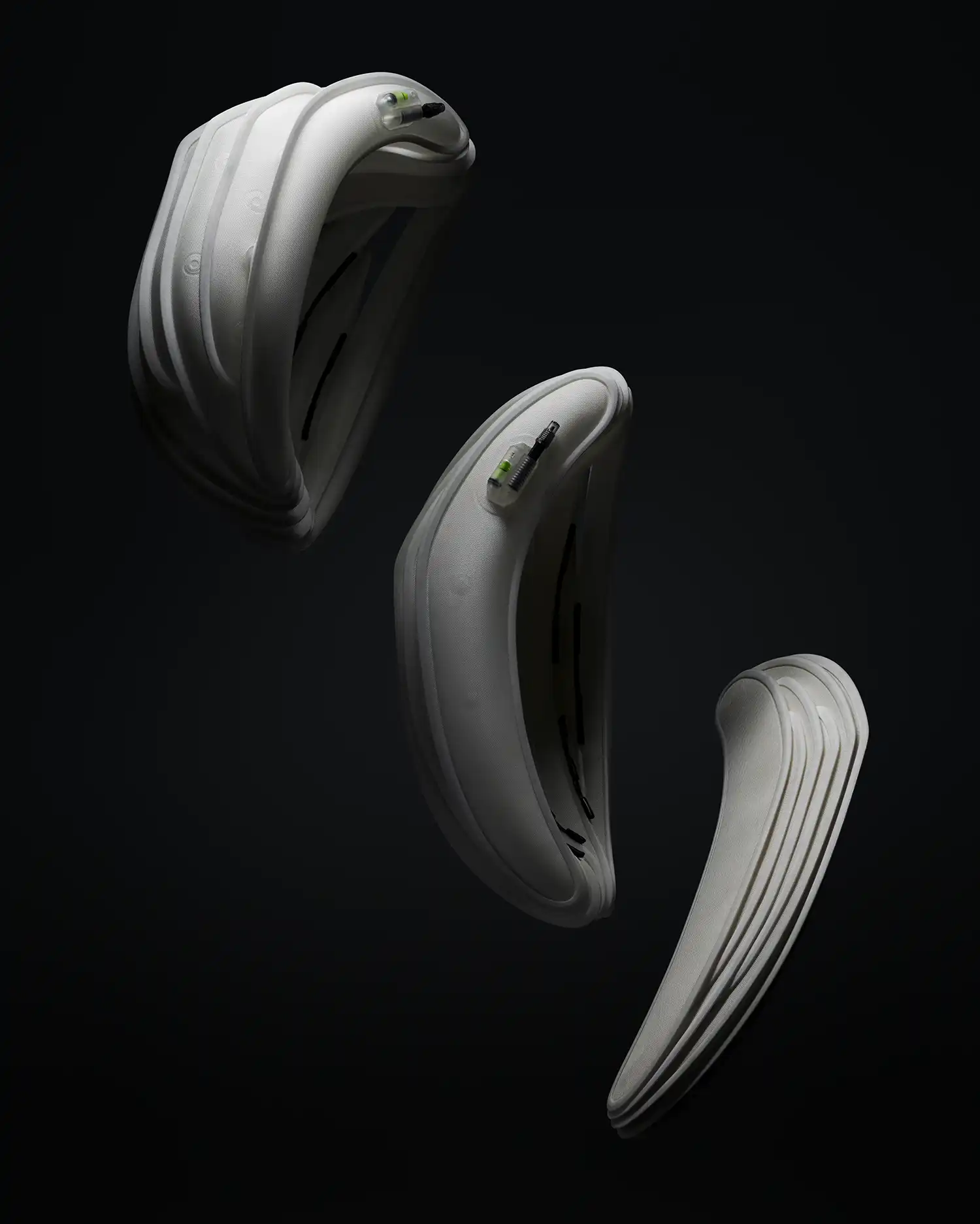 Three Ventete aH-1 helmets shown in various stages of deflation, floating against a black background.