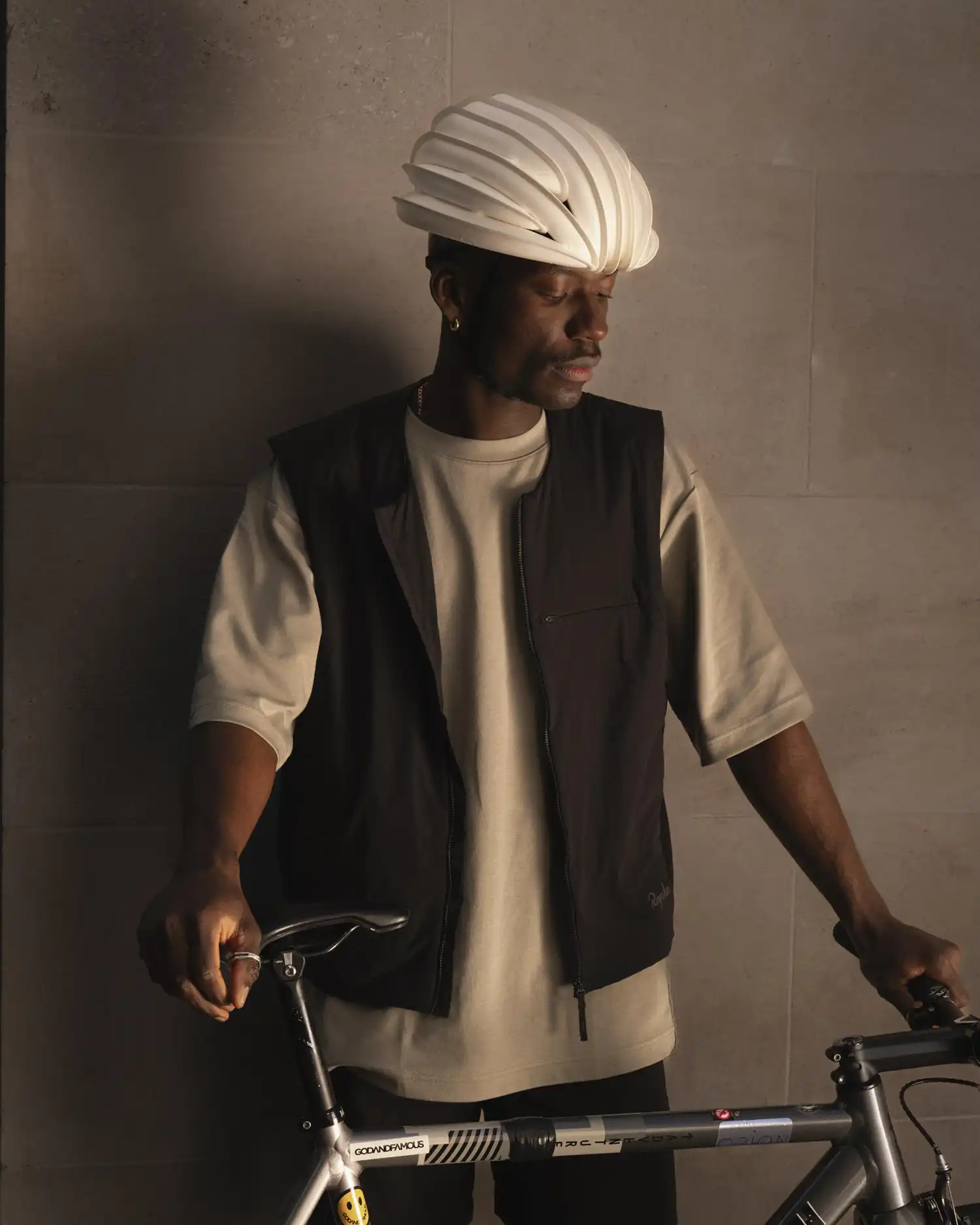 A person standing with a bicycle while wearing the white Ventete aH-1 inflatable helmet.