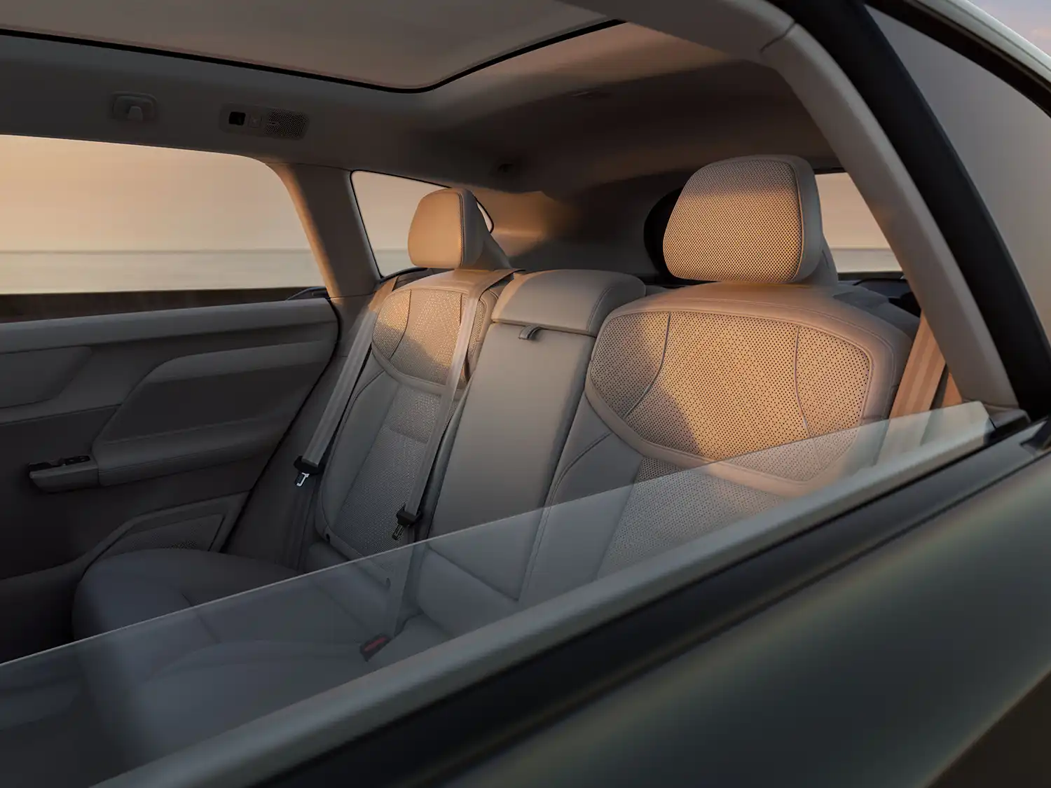 Rear passenger seats of the Volvo EX60 with perforated upholstery and panoramic roof.