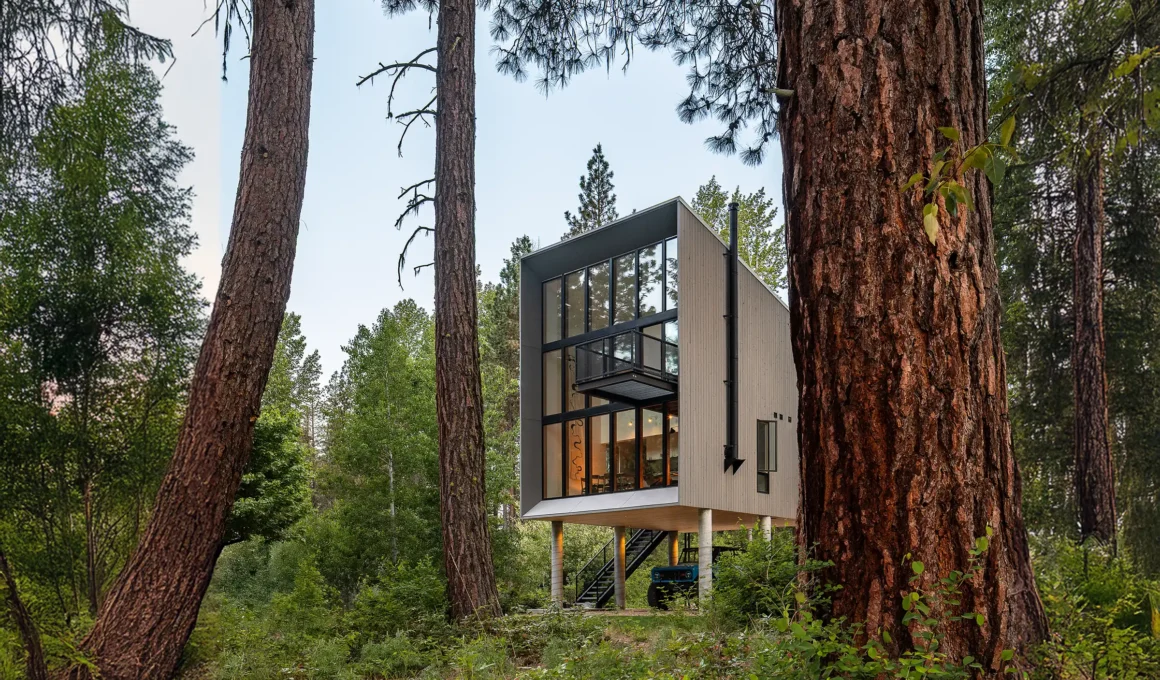 Modern 746-square-foot stilted cabin with a 24-foot window wall and cantilevered steel deck nestled in the Ponderosa pine forest of Plain, Washington.