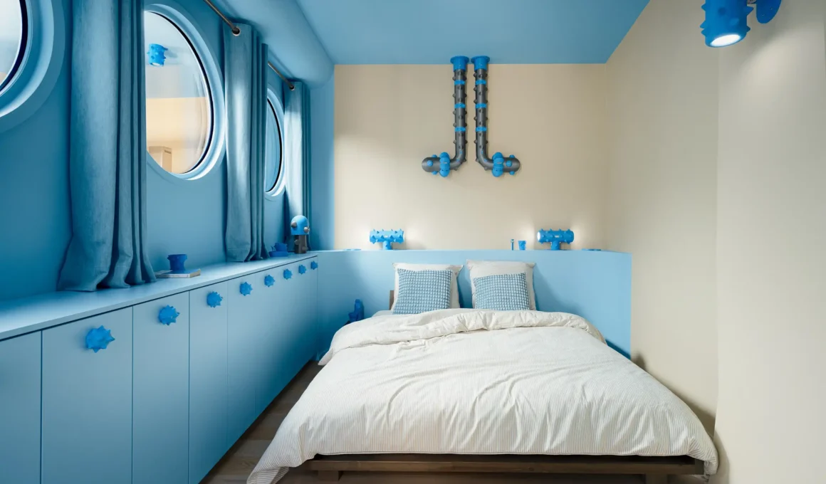 The bedroom serves as a subaquatic retreat, featuring porthole windows and industrial-inspired blue piping.