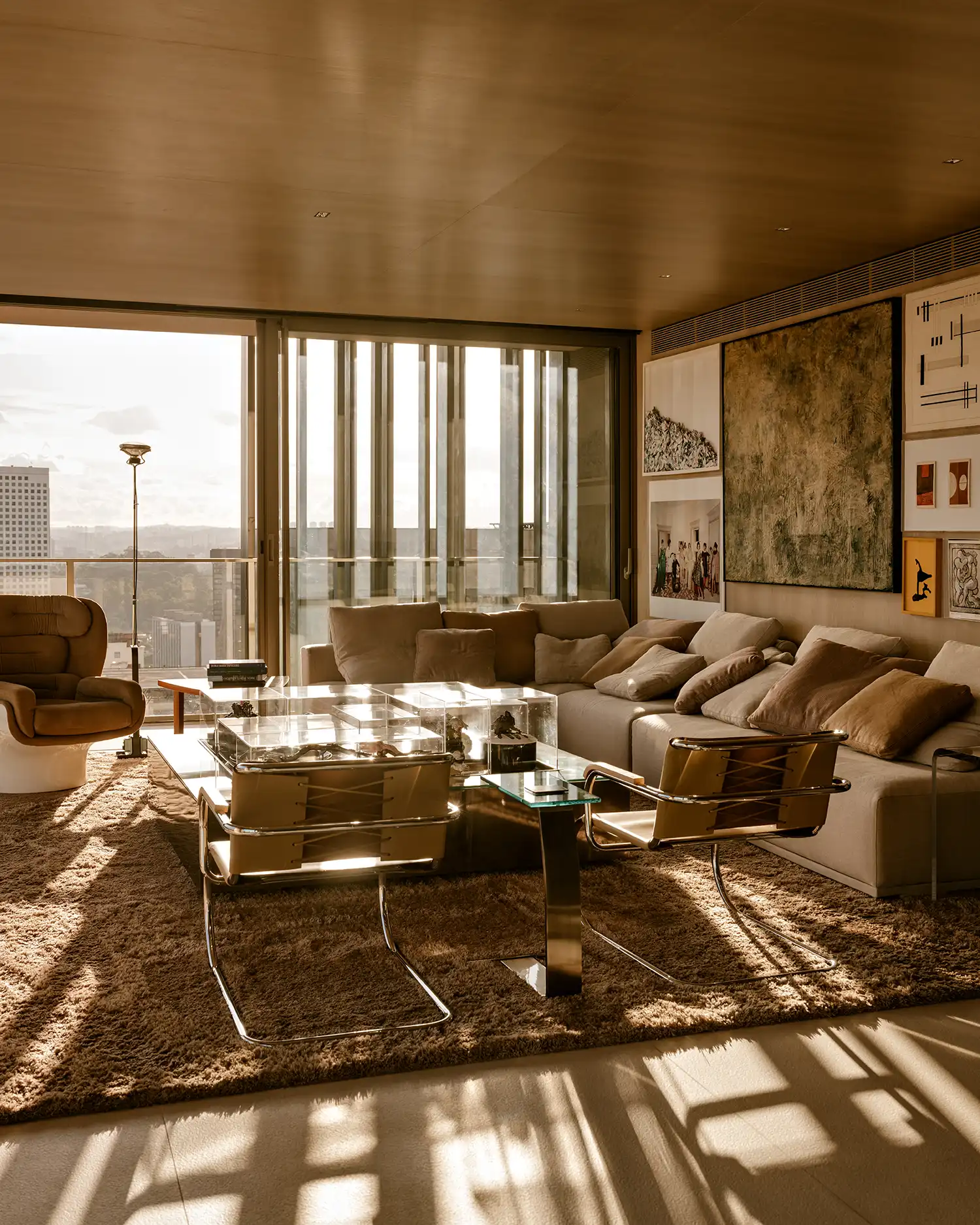 Sunlit living room in São Paulo with modular sofa and curated art gallery wall
