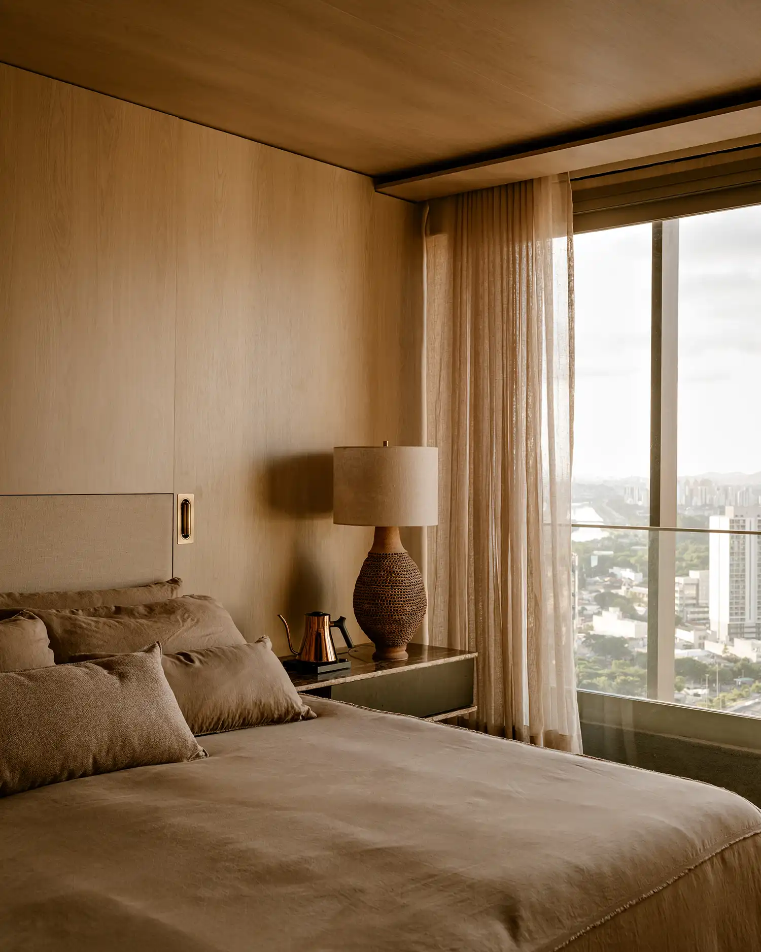 Master bedroom detail with wood paneling and vintage ceramic table lamp