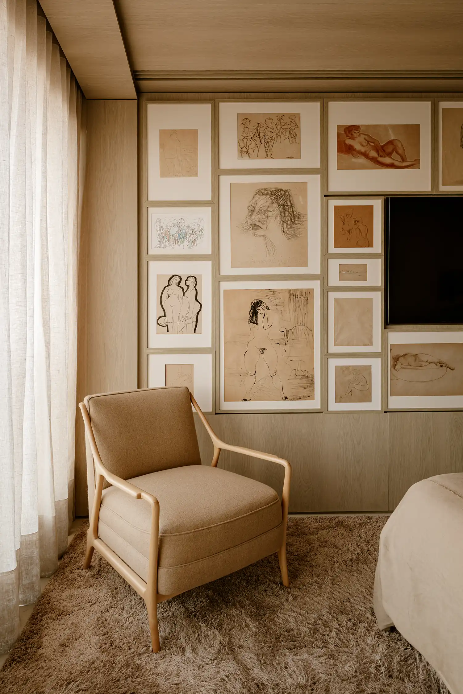 Interior detail of bedroom armchair and gallery wall of sketches
