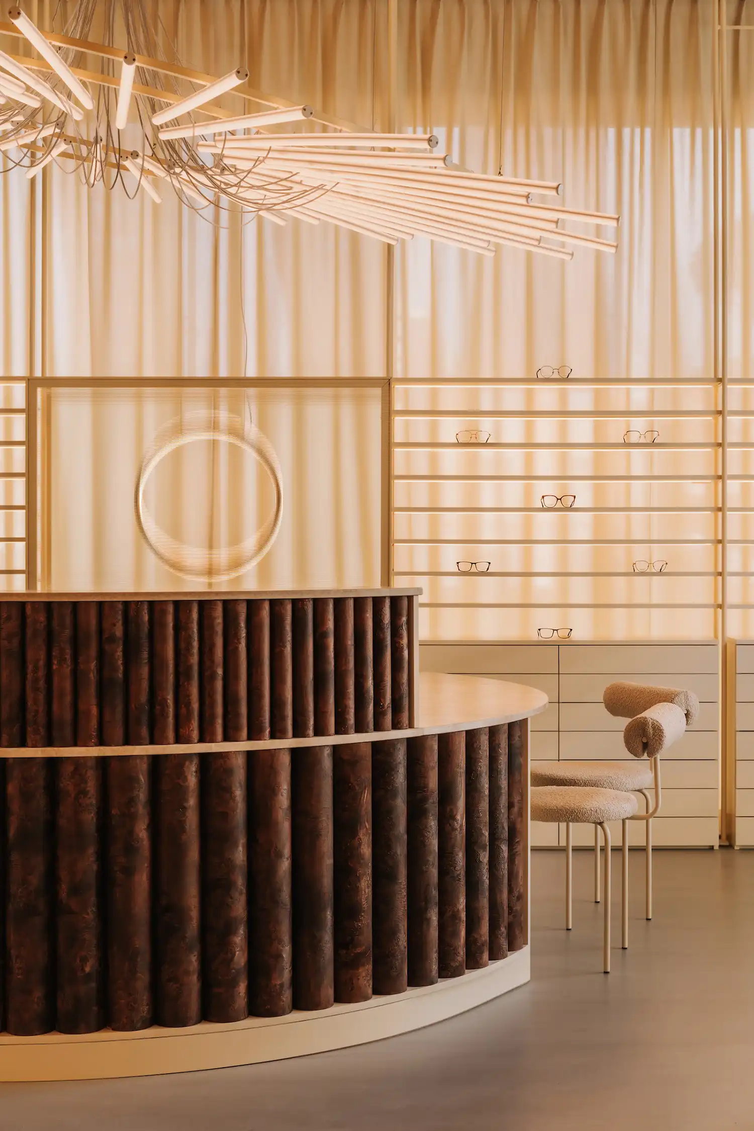 Textured wooden reception desk with linear light installation in a warm-toned interior.