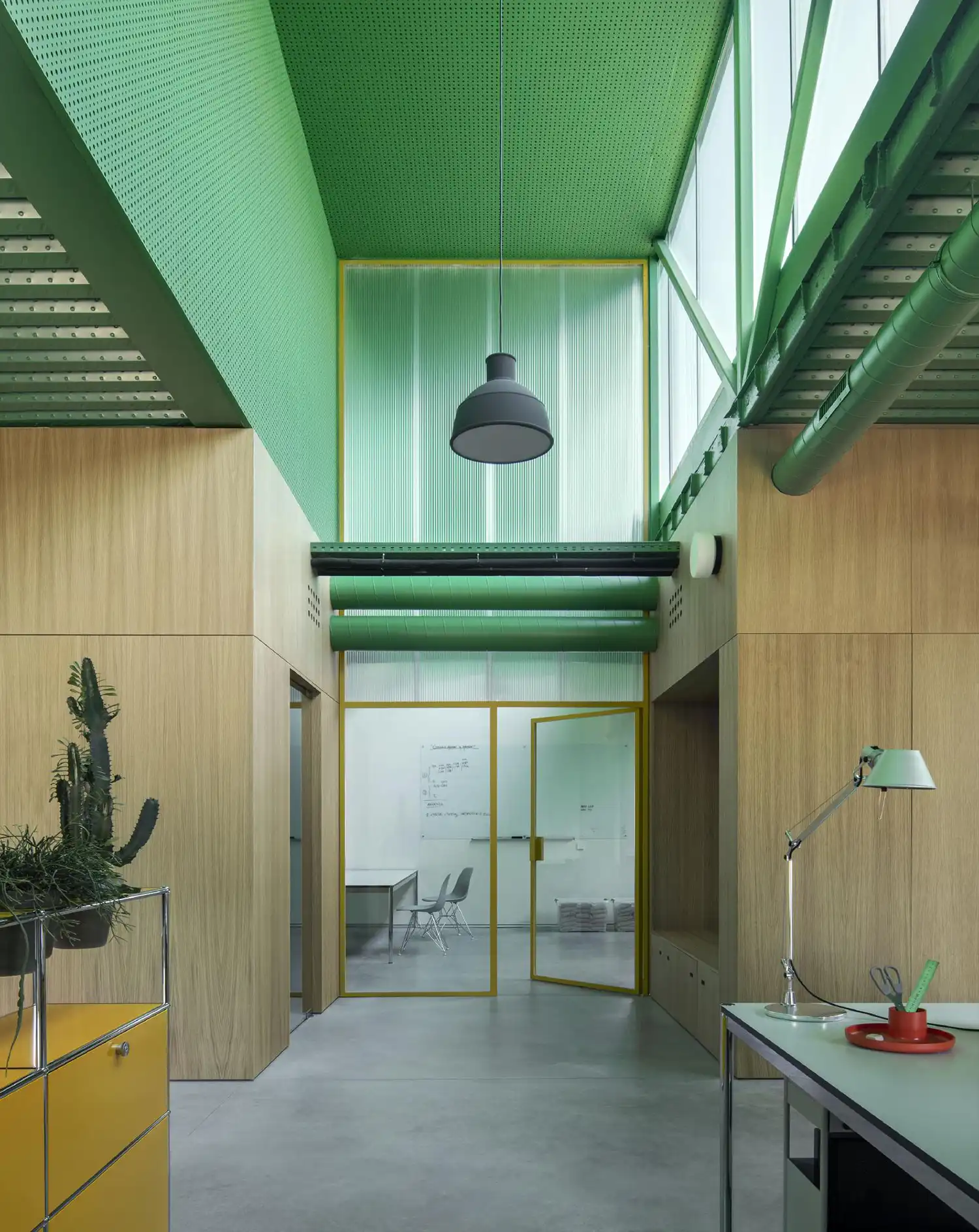 Interior office view with green industrial ceilings and wood-paneled walls