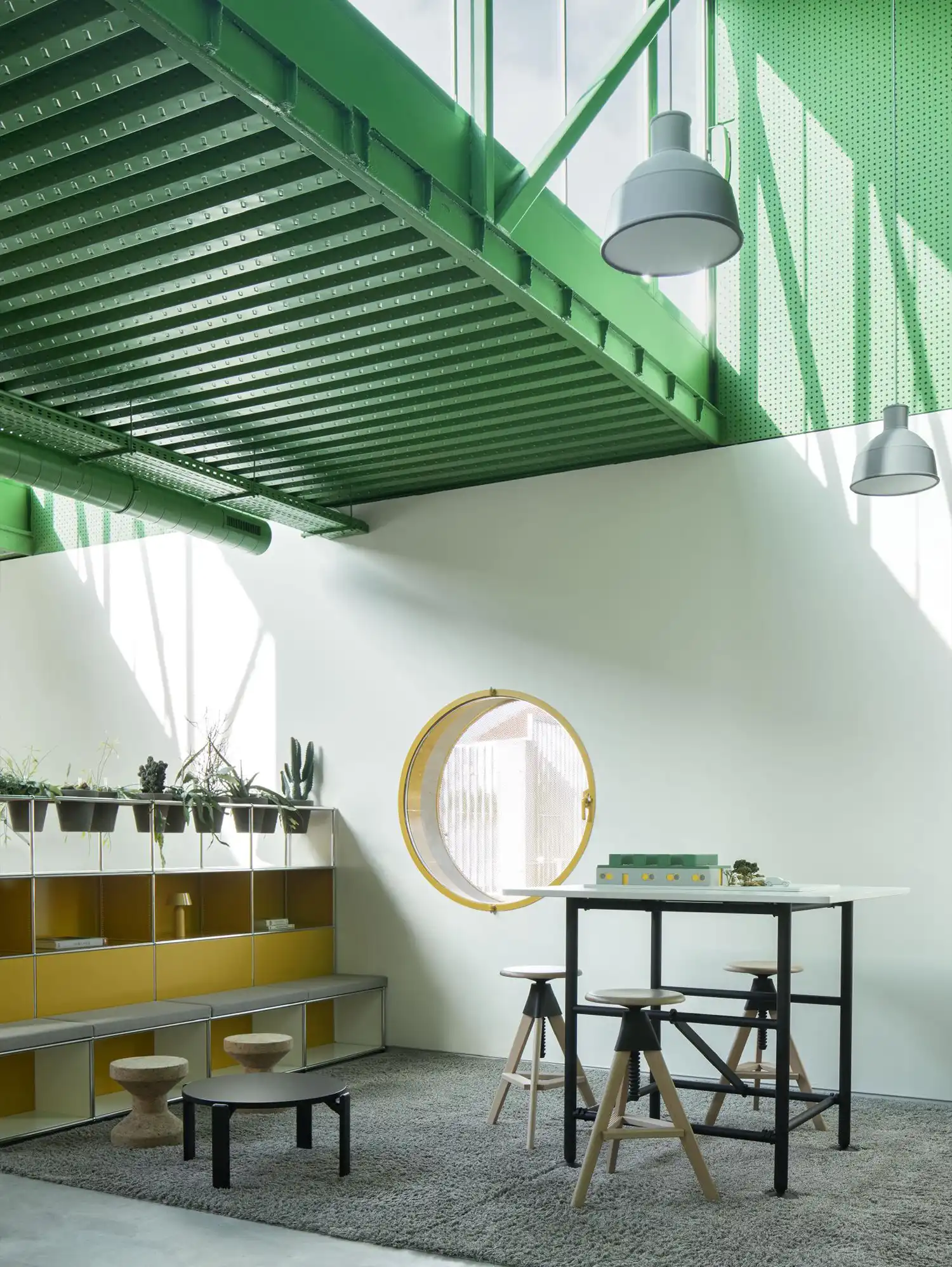 Open collaboration area with green metal ceilings and yellow shelving