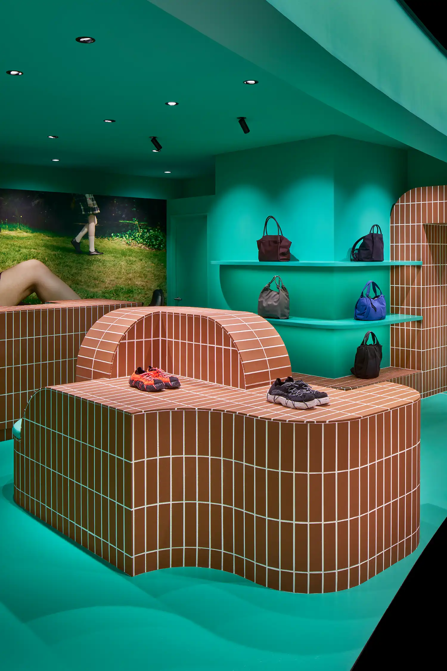 Close-up of curved, undulating terracotta tile furniture in a bright teal room.