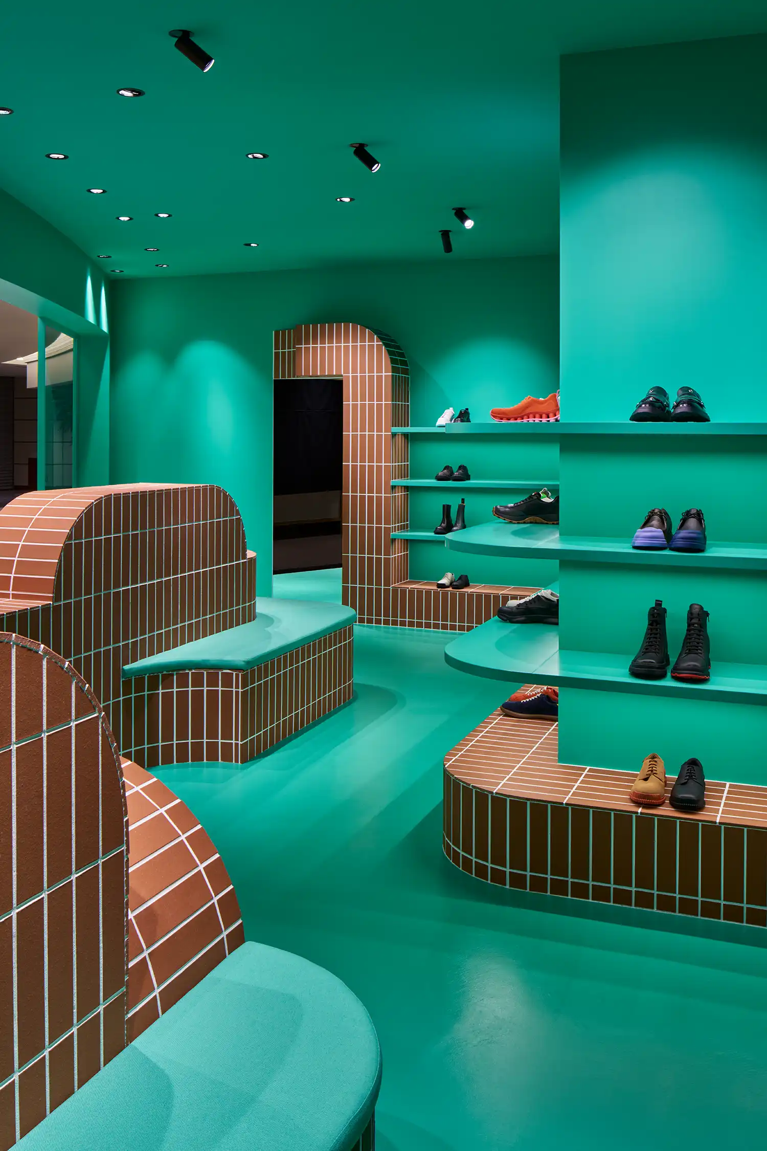 Perspective view of various heights of terracotta displays against a teal interior.