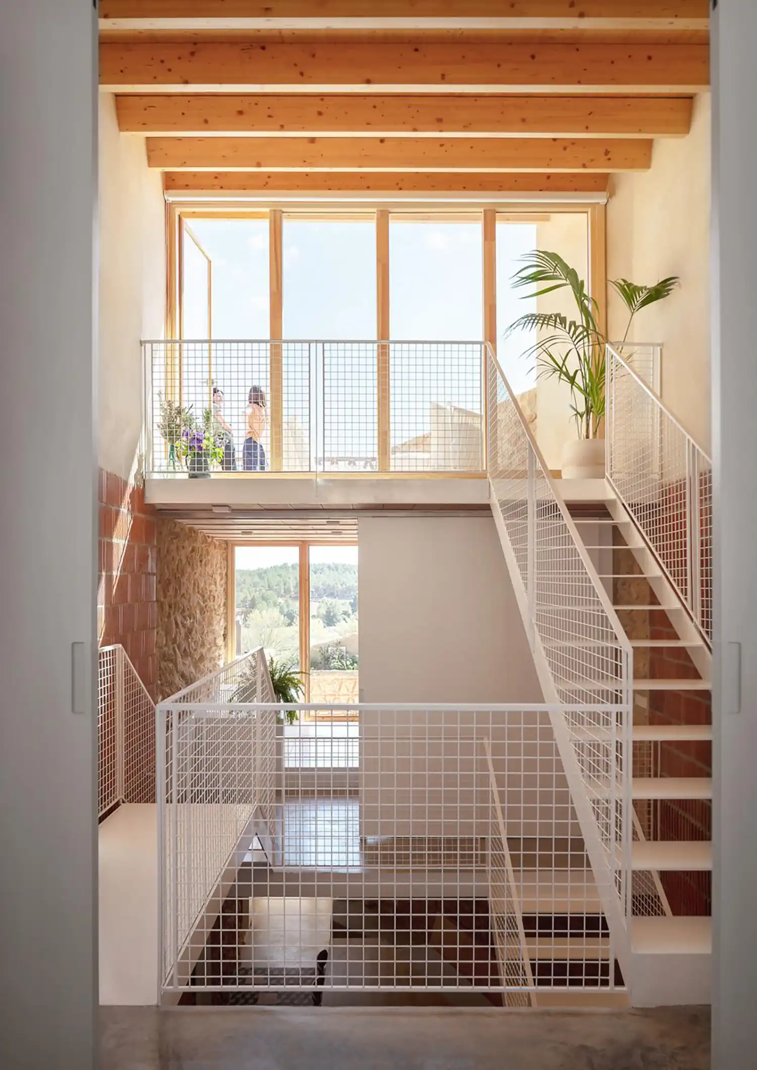 Vertical view through the central atrium showing white mesh walkways and large windows.