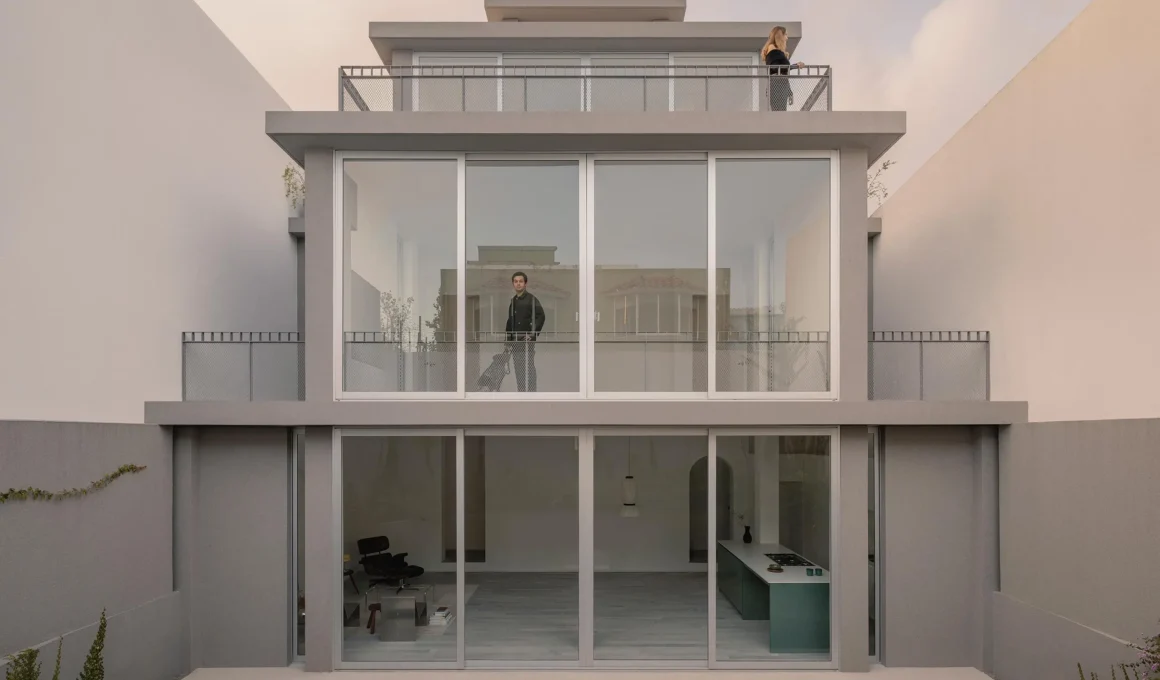 Austere concrete street facade of Casa Tlaloc with gray sliding gates.