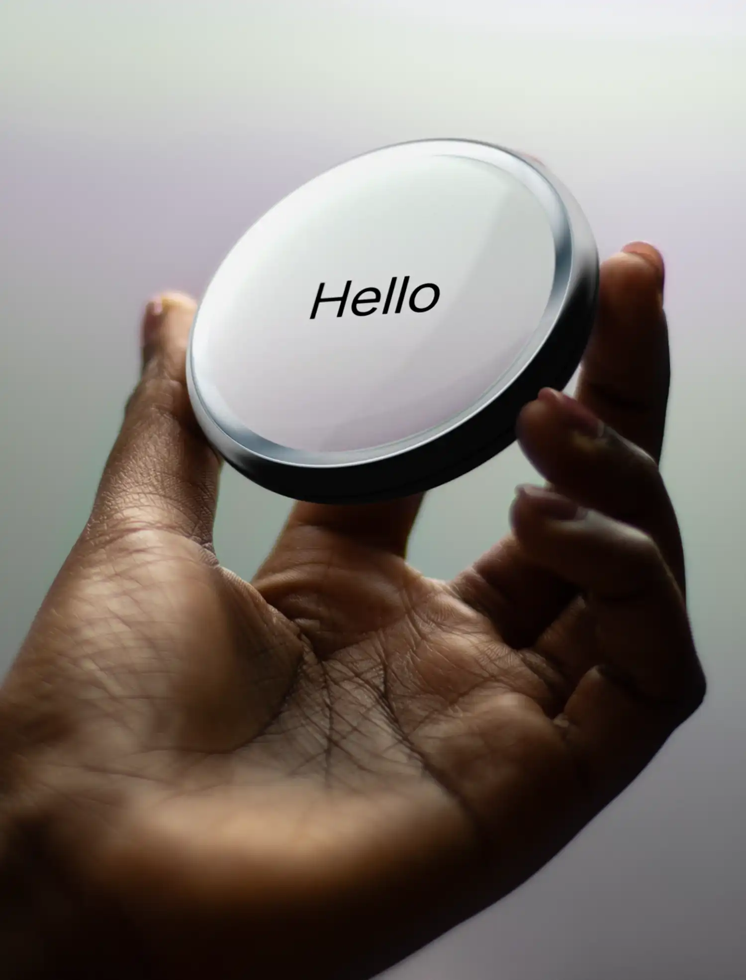 A hand holding the Pond handheld AI device showing a minimalist "Hello" interface.