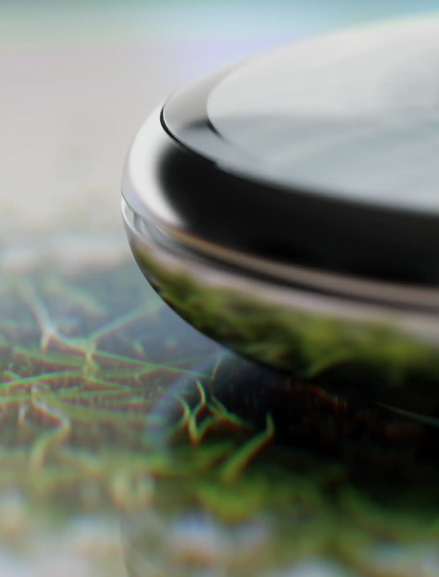Macro detail of the Pond device interface showing organic green textures beneath the surface.