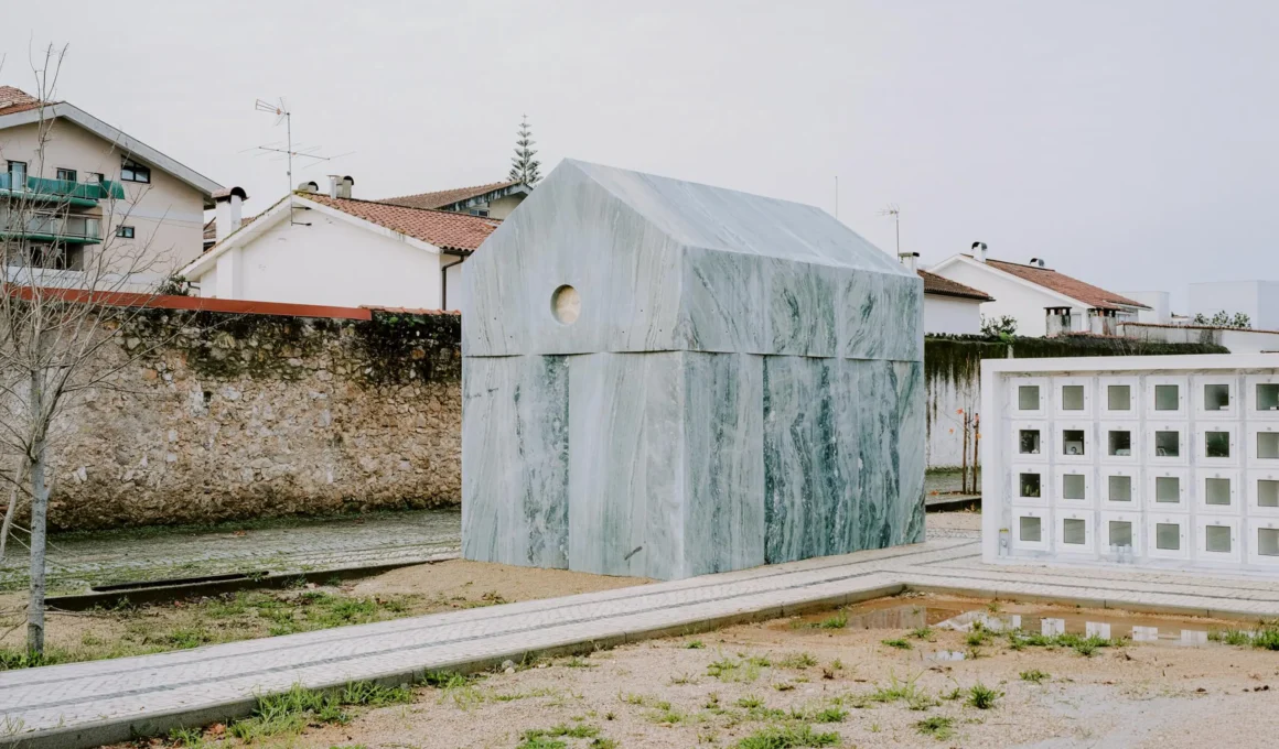 Side view of a monolithic Verde Viana marble tomb in a Portuguese cemetery.