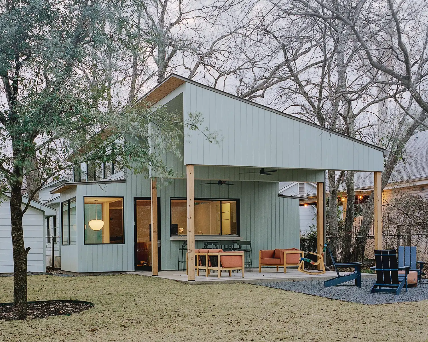 Modern light blue timber addition with a large covered terrace and outdoor seating.