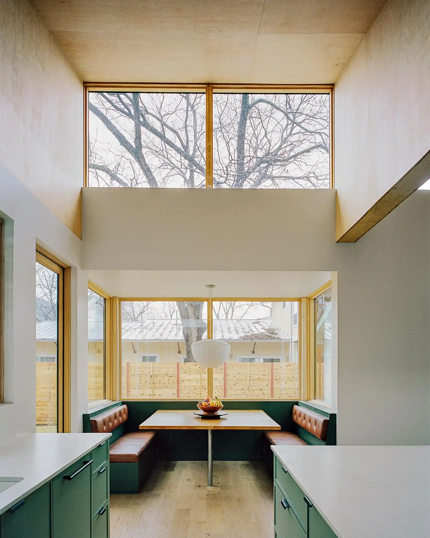 Built-in dining banquet with leather seating under a high clerestory window.