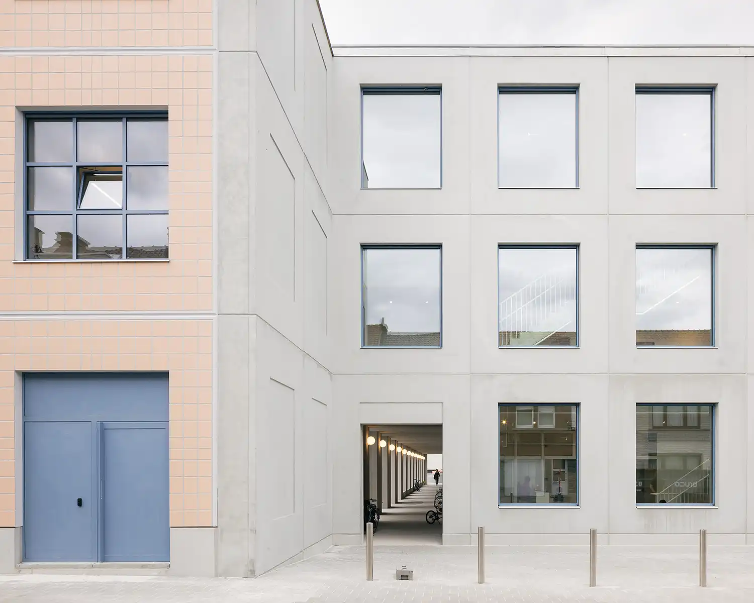 A transition point between the pink tiled facade and the grey prefab concrete facade of the campus.