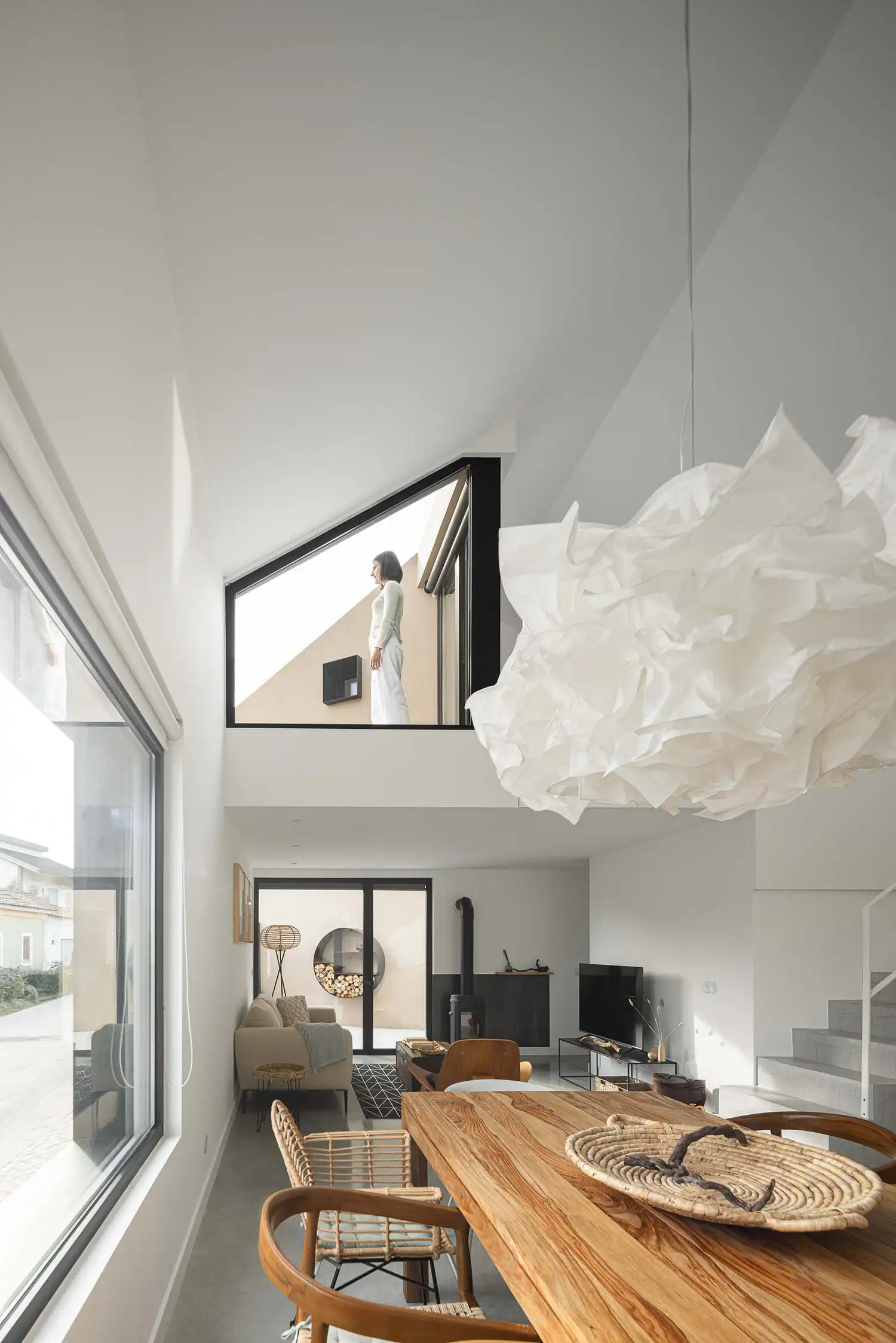 Bright double-height interior of Casinha Da Melroeira with large paper lamp