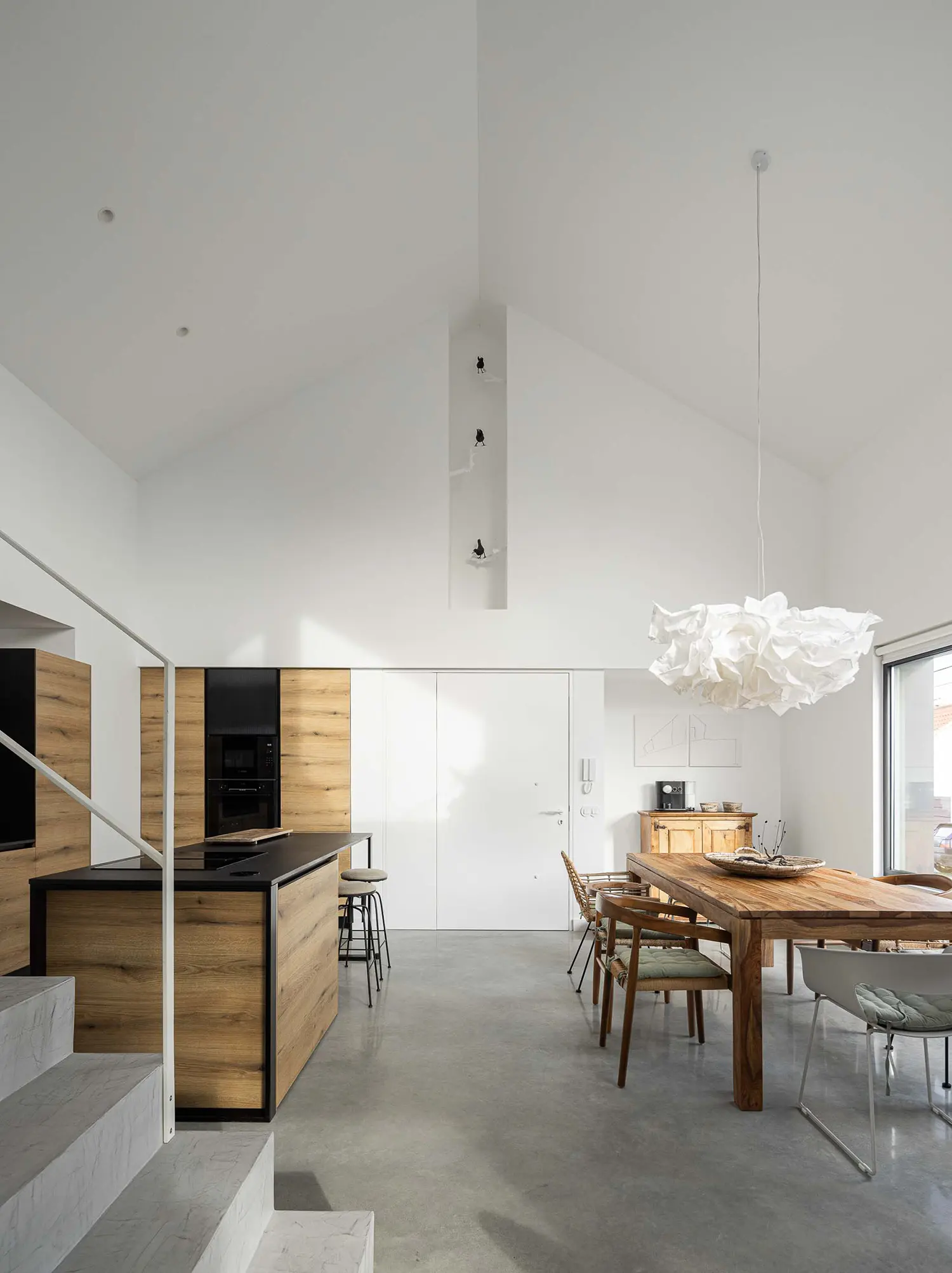 Minimalist kitchen and dining area with high pitched ceiling