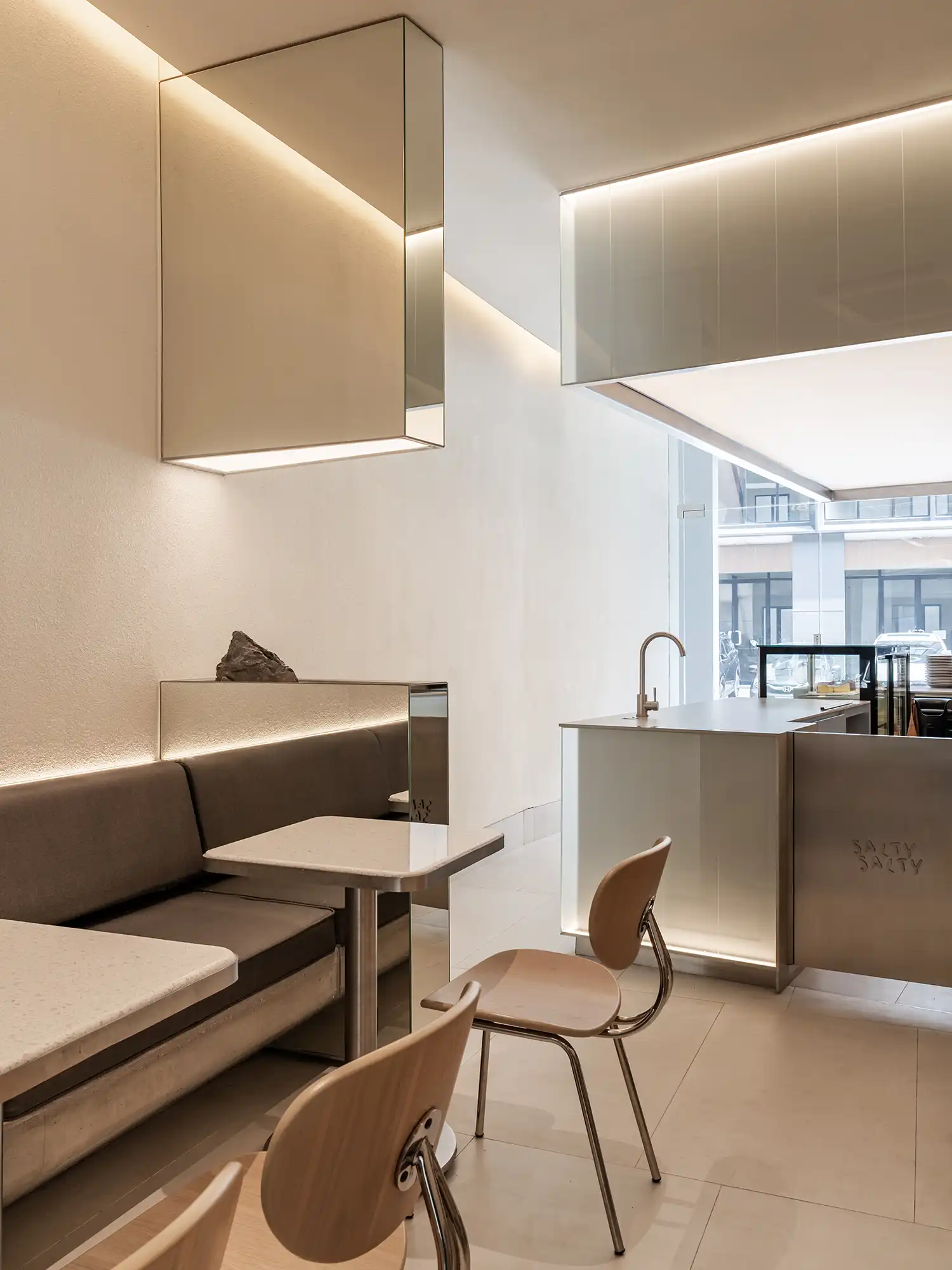 View of the coffee counter from the seating area with geometric light volumes.