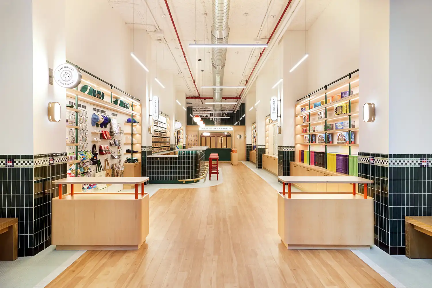 Linear view of a narrow retail interior with maple wood floors and high ceilings in NYC.