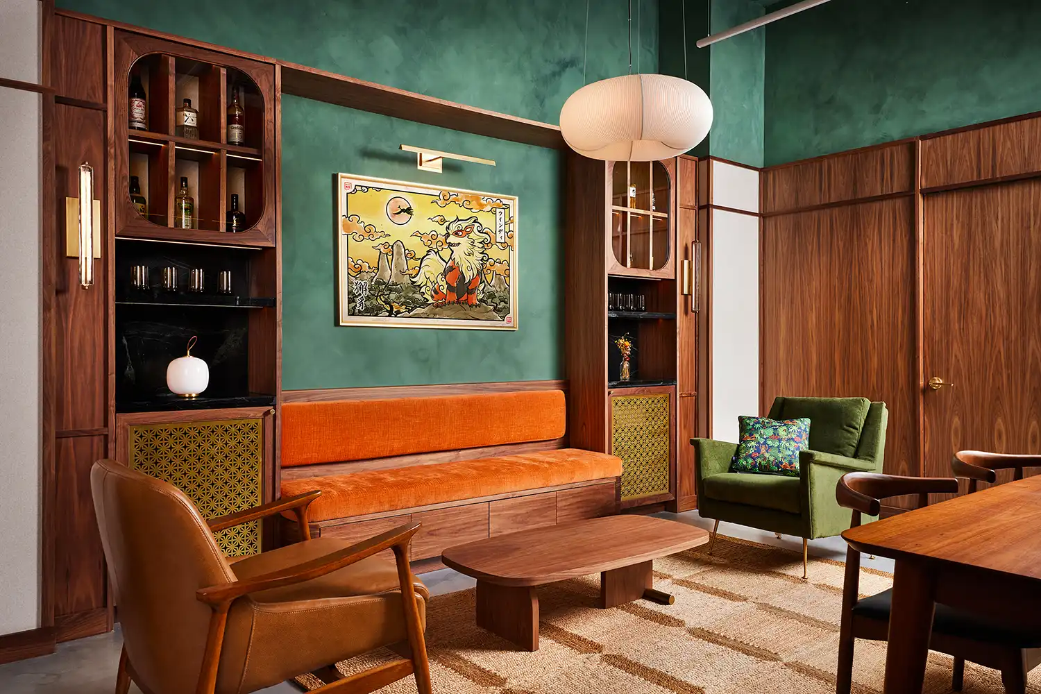 Sophisticated walnut-wrapped lounge with green walls, mid-century furniture, and Japanese art.