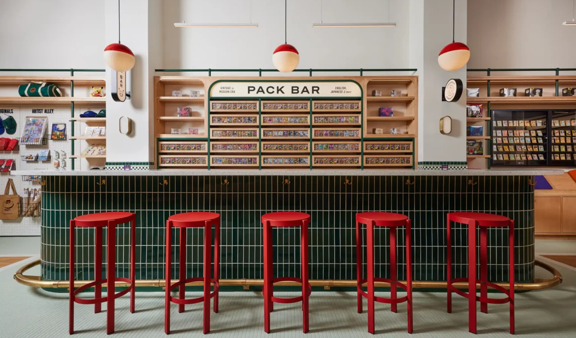 Green subway tile bar with red stools and Pokéball pendant lights in a NYC store.