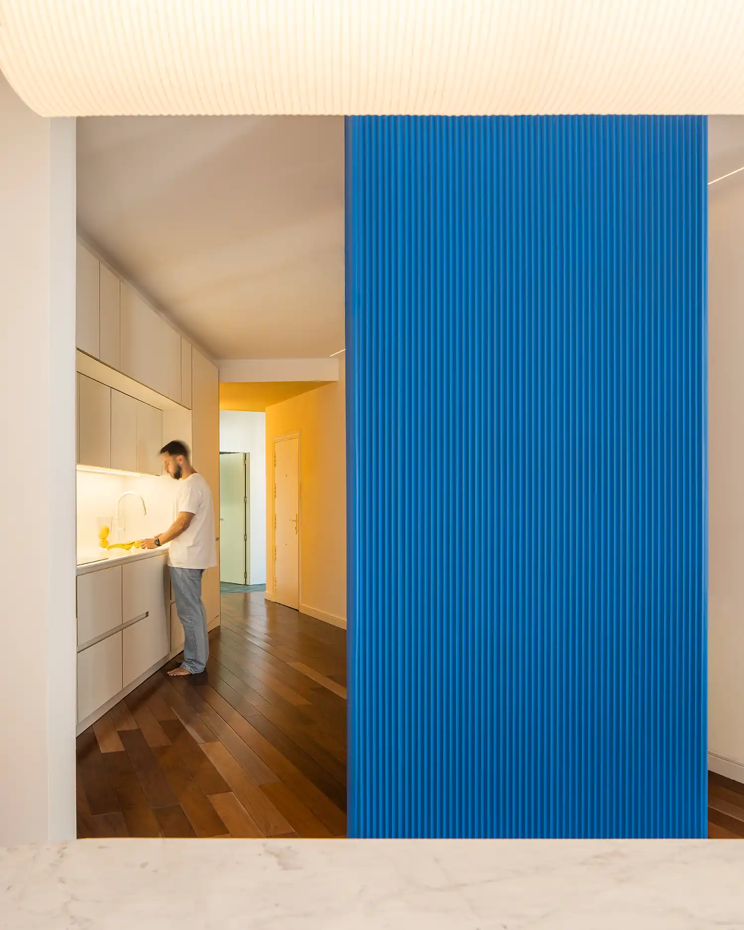 Minimalist white kitchen and yellow hallway entrance