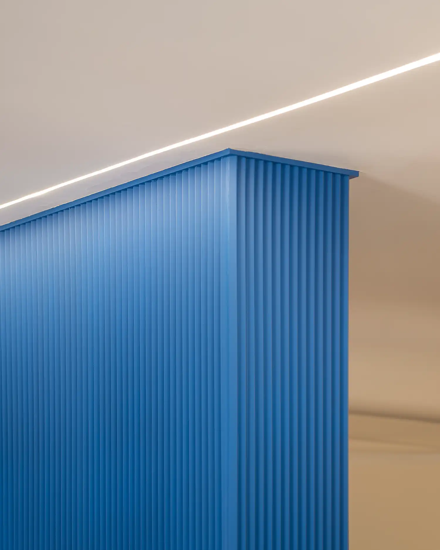 Detail of electric blue zigzag-textured column and recessed ceiling light