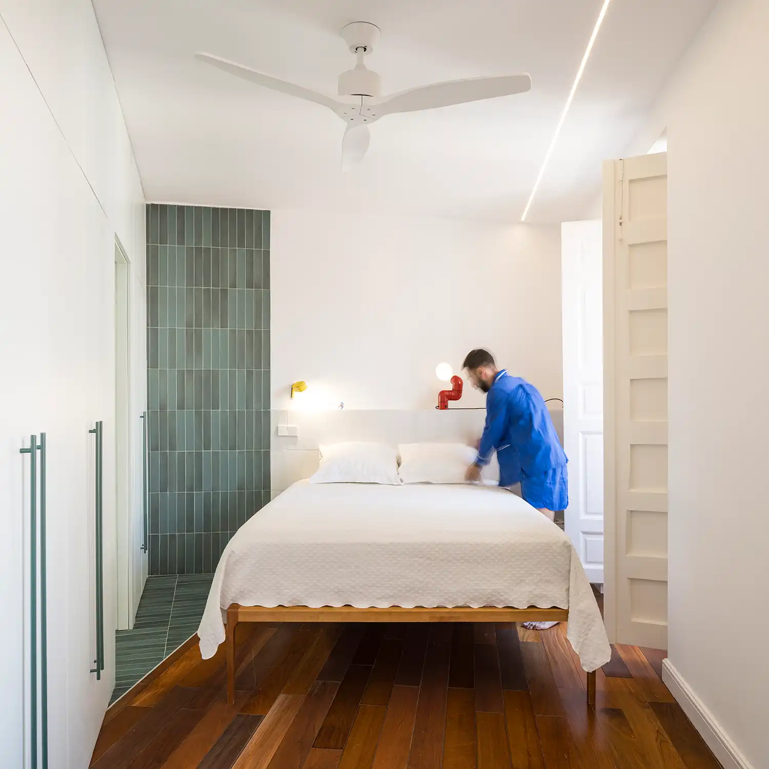 Bedroom with green tile accent wall and white shutters