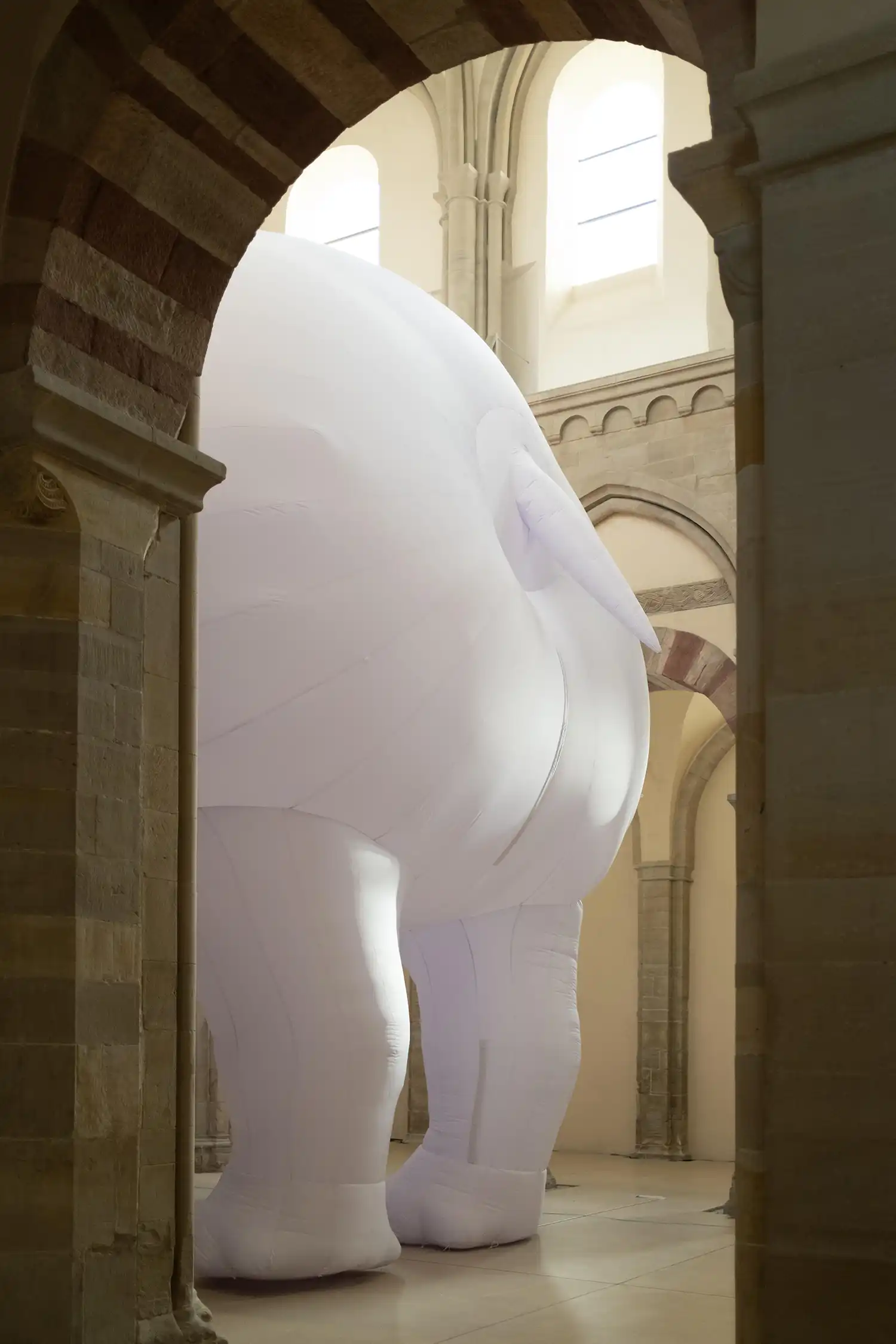 Rear view of white inflatable rhinoceros in medieval church