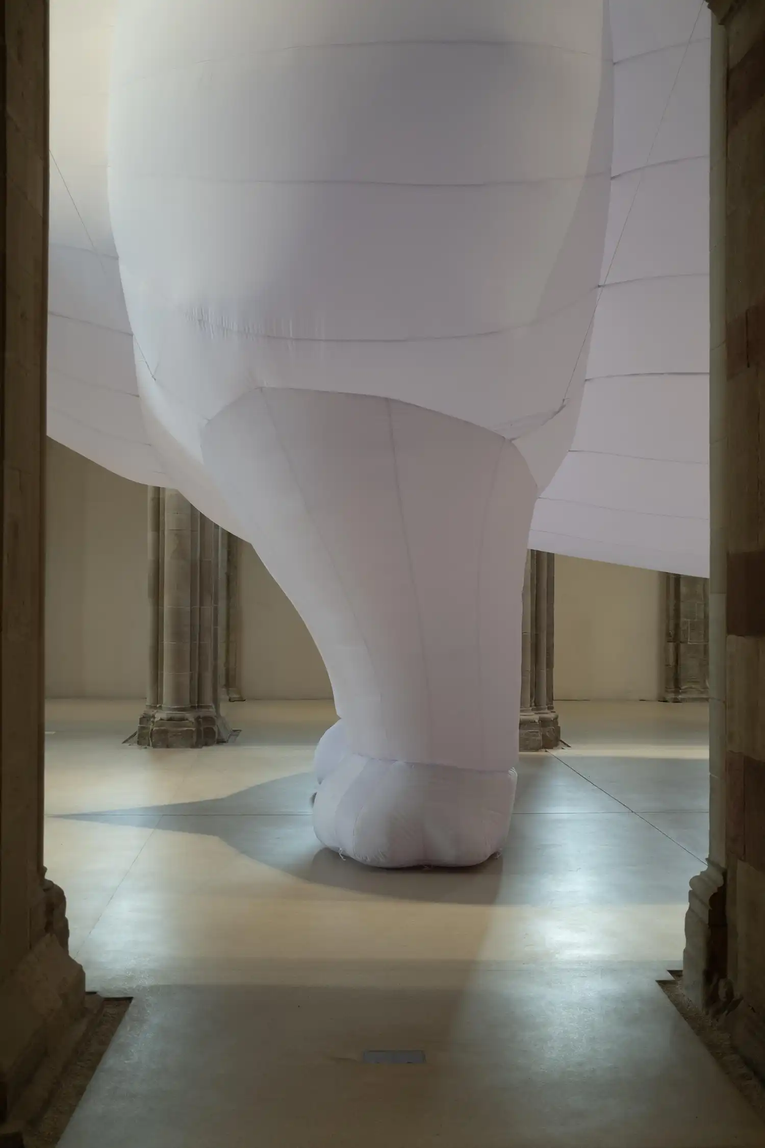Close-up of inflatable rhinoceros leg on stone floor of church